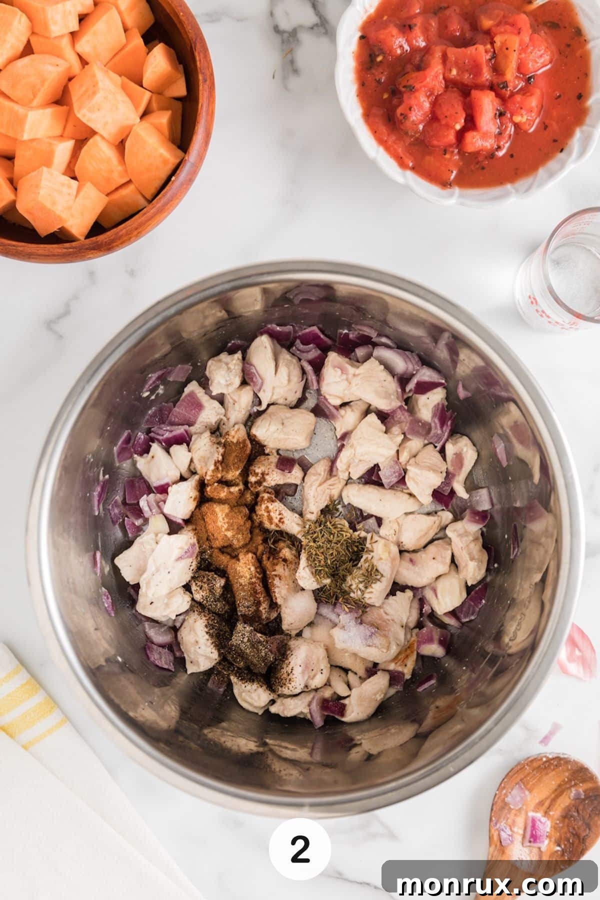 chicken and sweet potato cooking in instant pot step two, showing seasonings being added.
