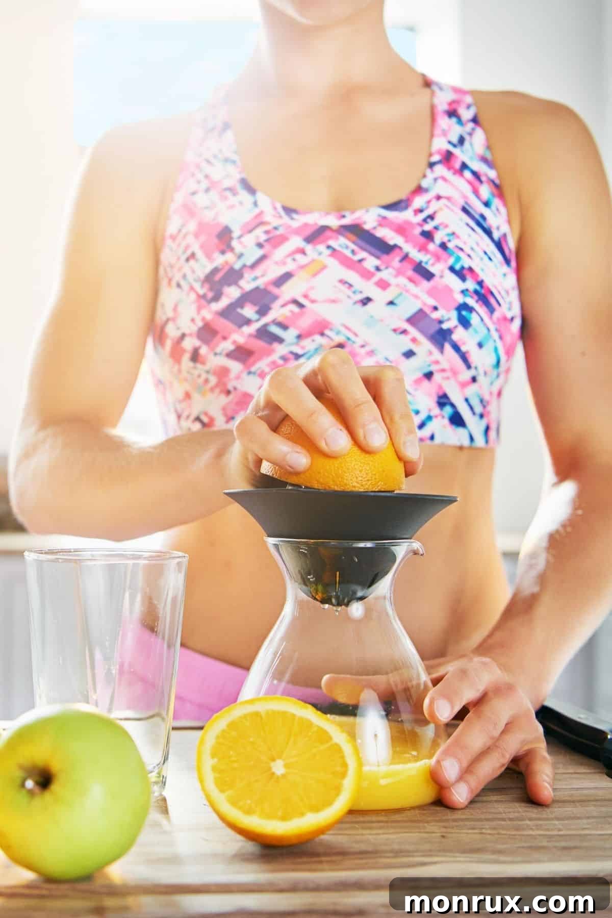 A woman in a bright kitchen making juice, emphasizing a fresh, energetic start to the day.