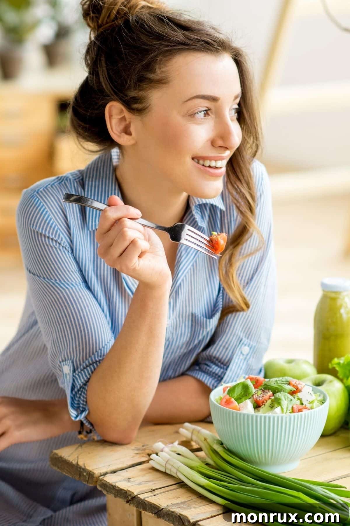 A smiling woman enjoying a fresh salad, highlighting the pleasure of healthy eating.