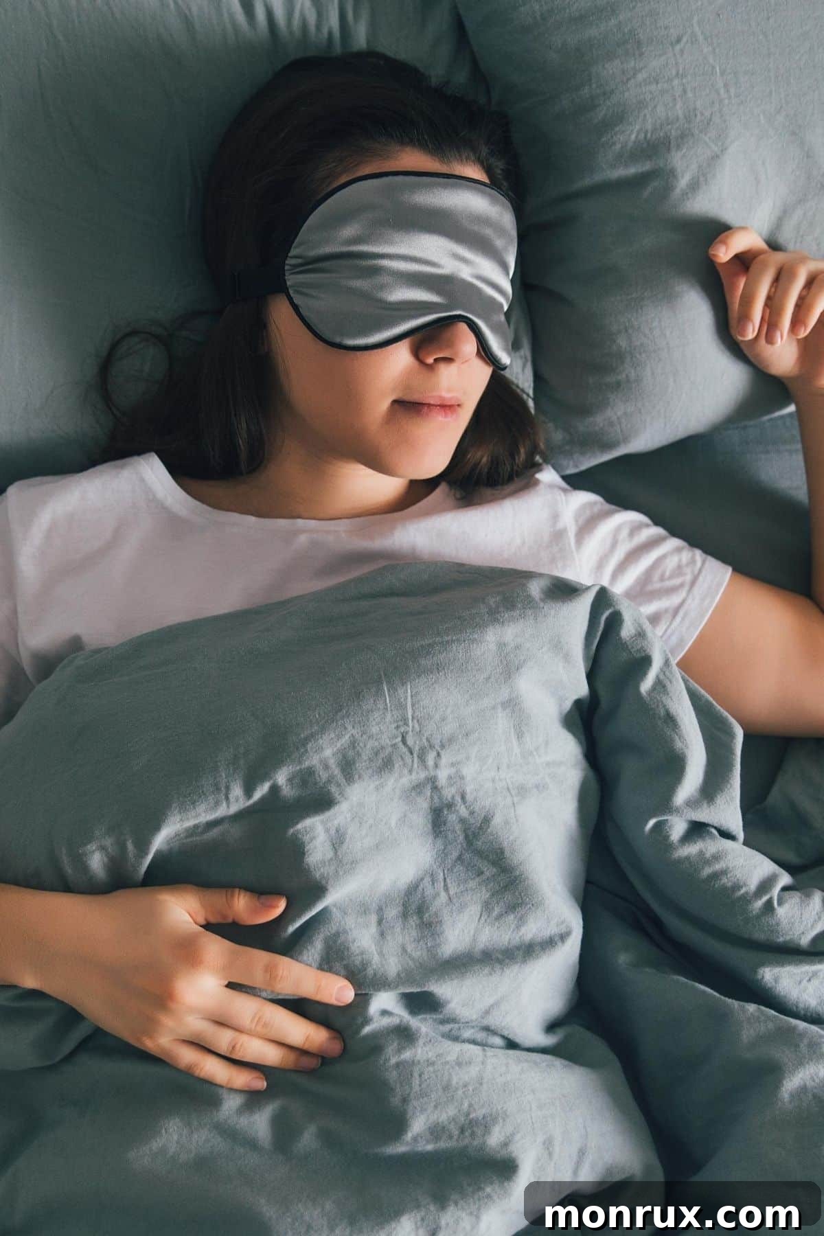 A woman sleeping peacefully in bed with an eye mask, emphasizing restful sleep.