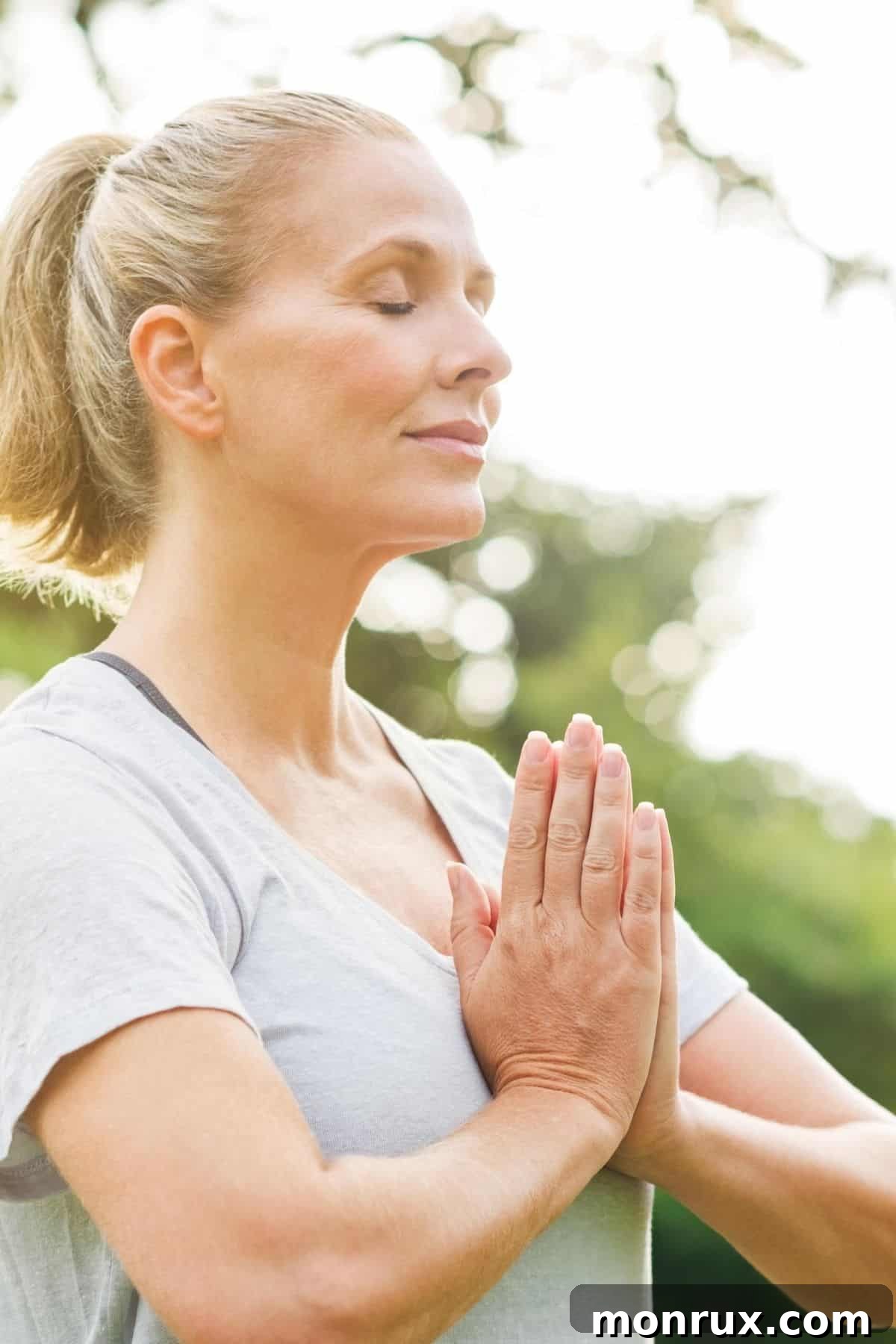 A woman meditating outdoors, symbolizing stress reduction and inner peace.