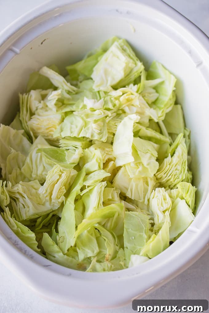 Freshly chopped cabbage layered in a crockpot, ready for the corned beef to be placed on top and cooked.