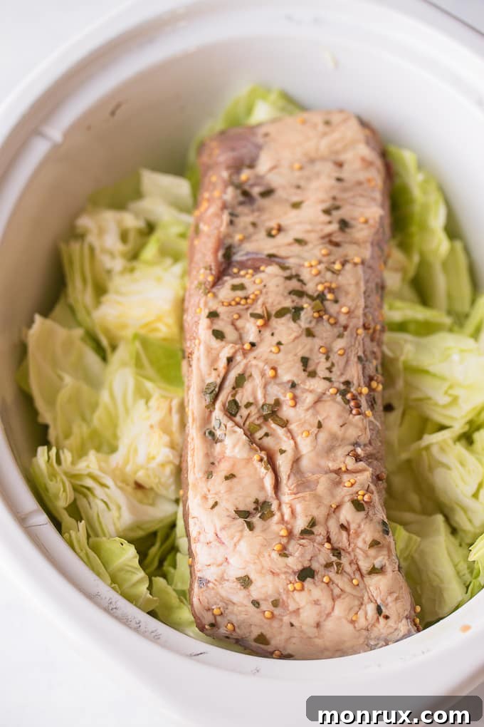 A slow cooker filled with corned beef and cabbage, ready to begin its long, slow cooking process.