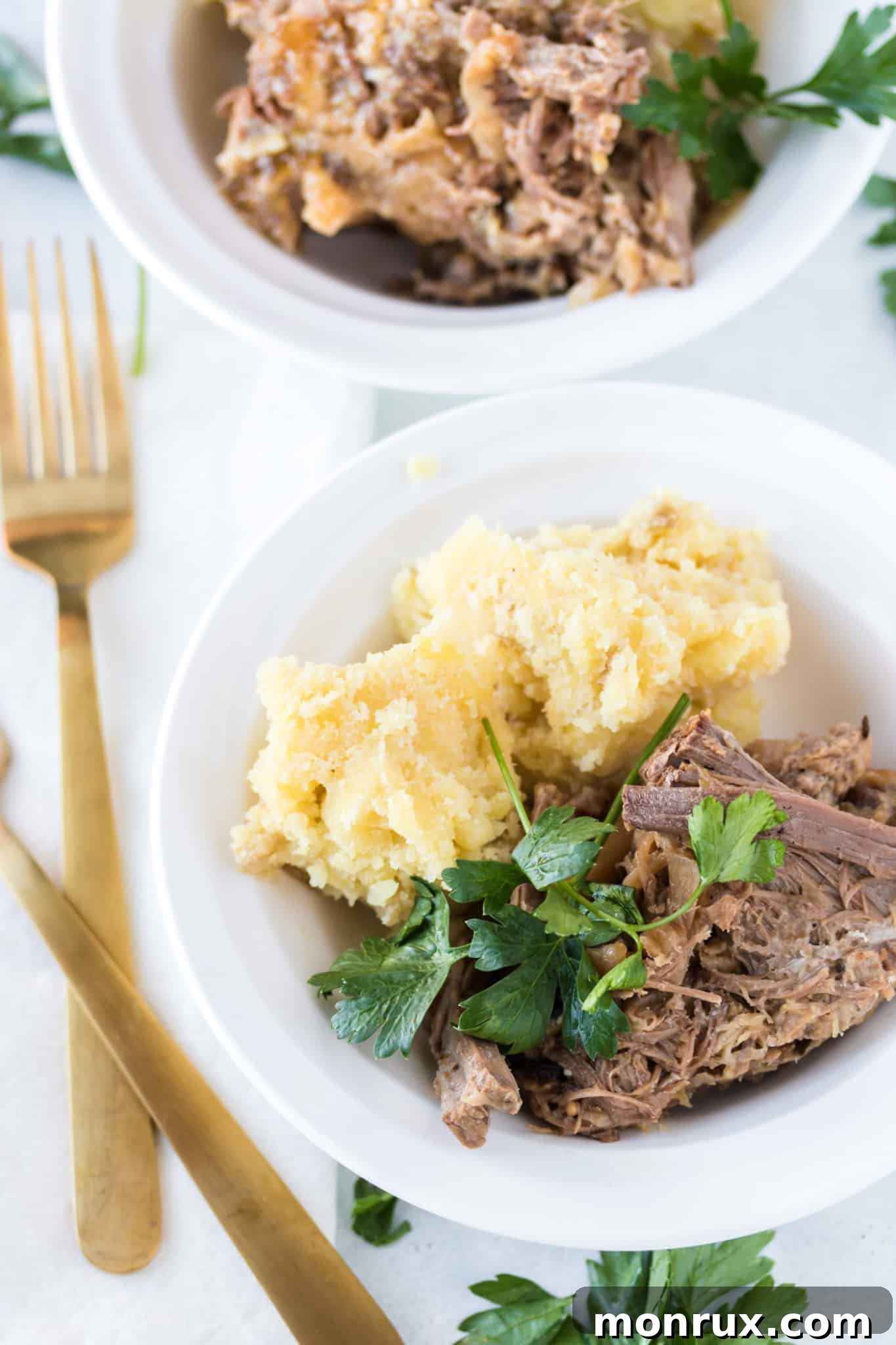 Two bowls of perfectly cooked corned beef and cabbage, garnished and ready to be enjoyed.