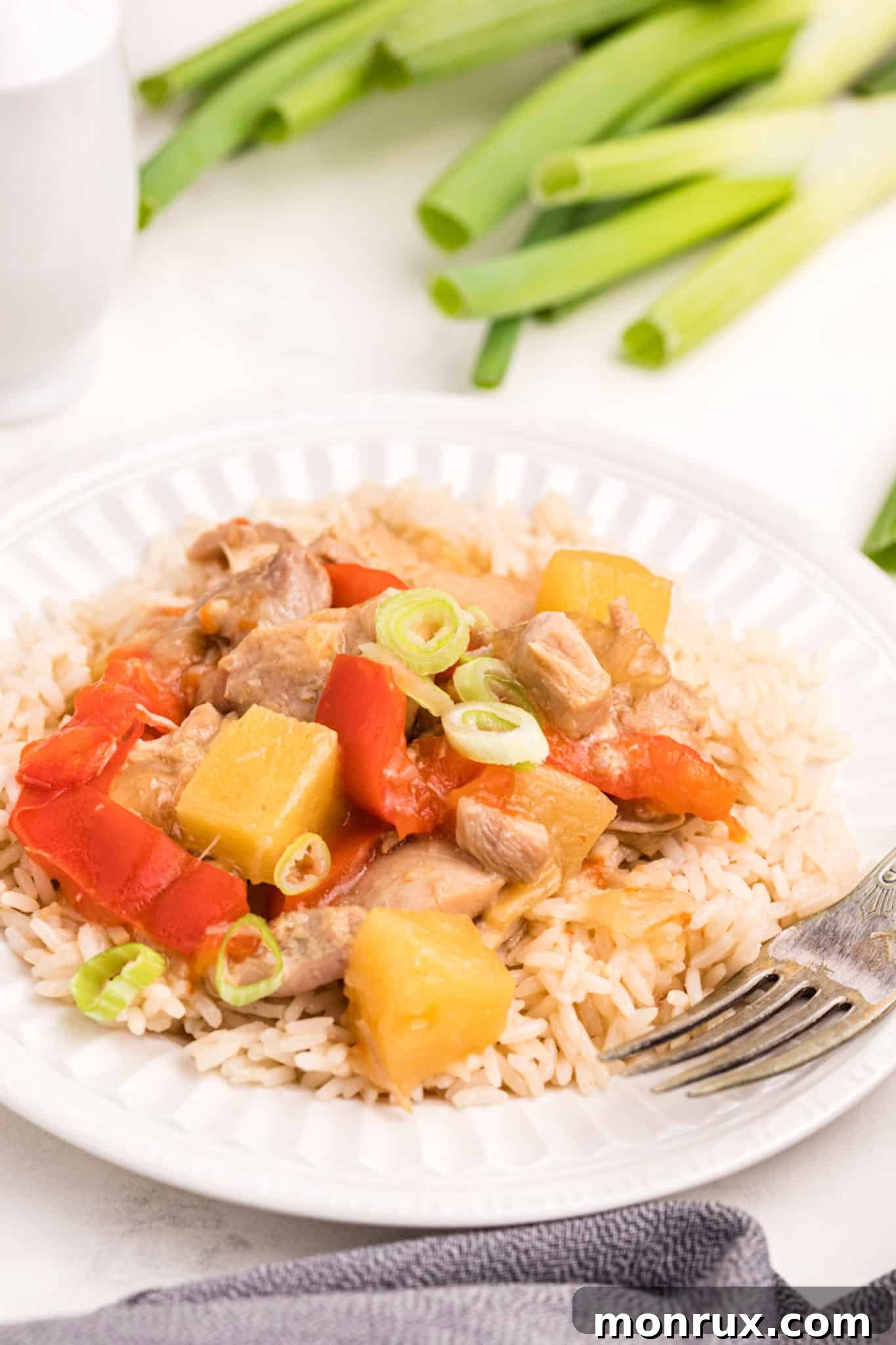 Cooked Instant Pot Pineapple Chicken served with rice, garnished with green onions.