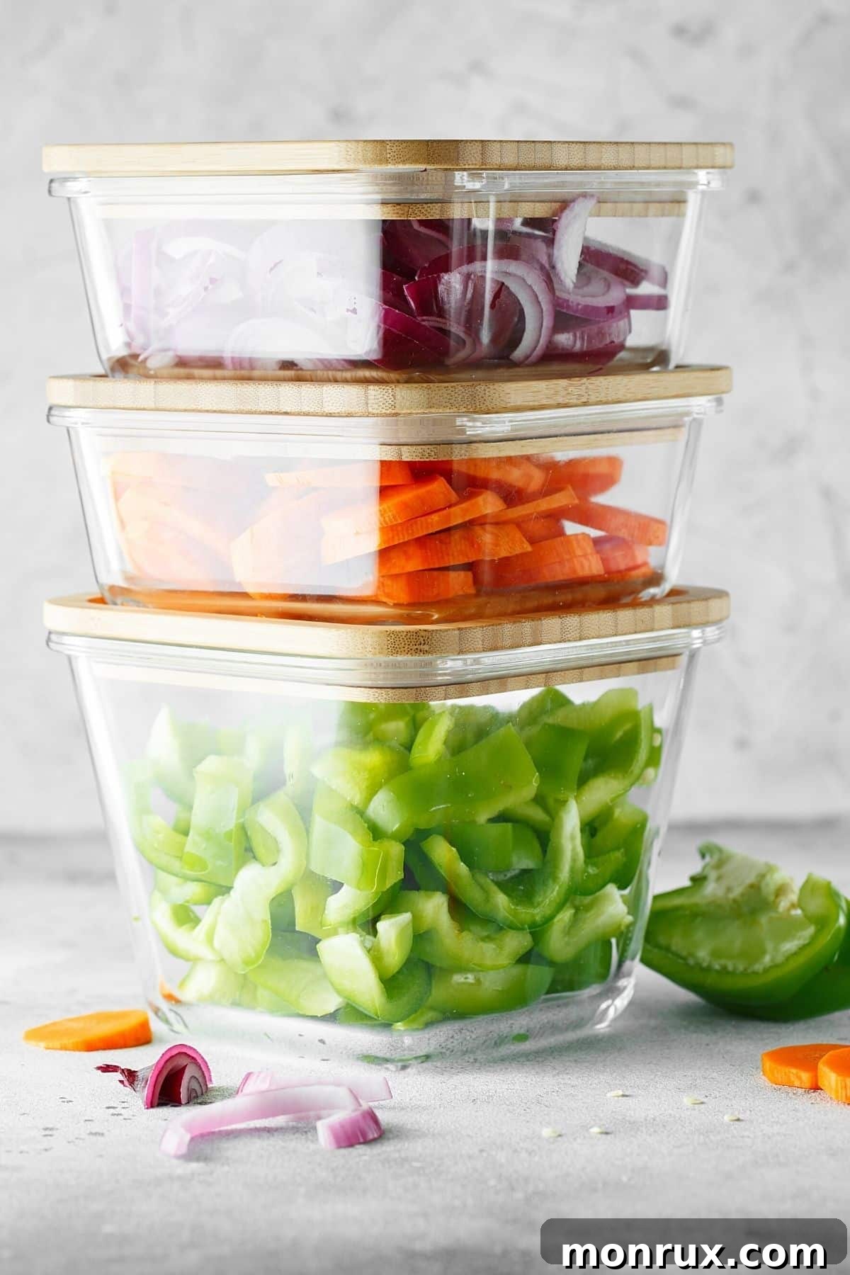 Assortment of vibrant, pre-chopped vegetables organized in square glass containers, ready for meal prep.