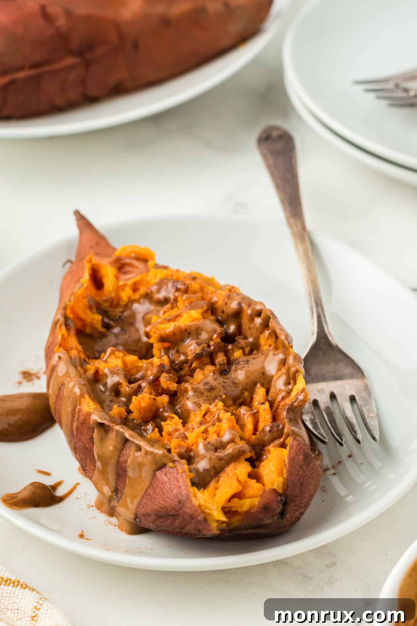 Instant Pot sweet potato topped with almond butter and cinnamon, ready to eat.