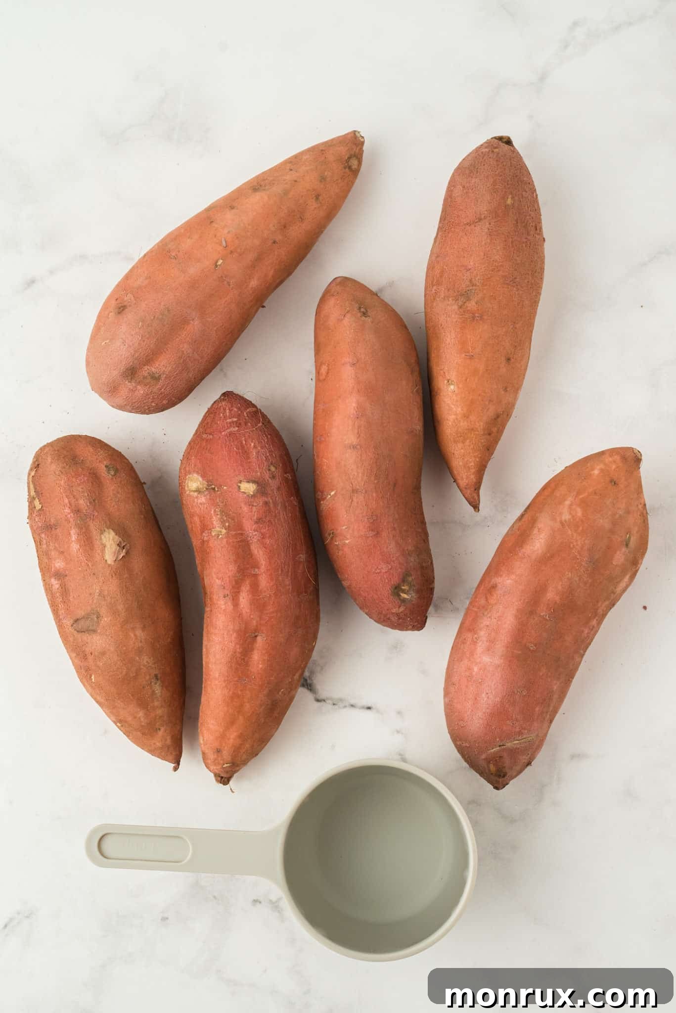 Uncooked sweet potatoes and water on a tabletop, ready for the Instant Pot.
