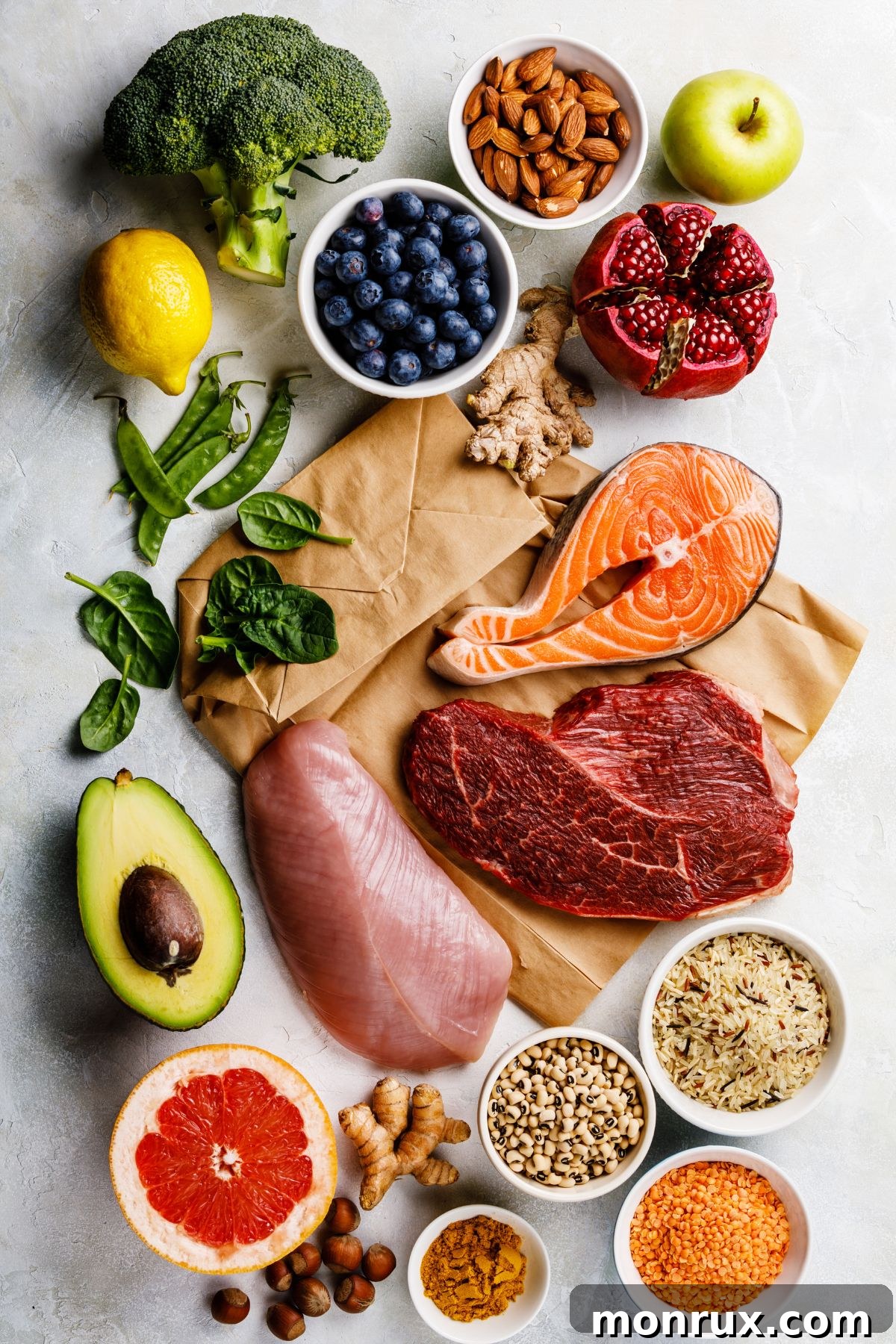 A vibrant display of fresh, unprocessed clean eating foods including colorful fruits, vegetables, nuts, seeds, and whole grains arranged beautifully on a rustic wooden table.