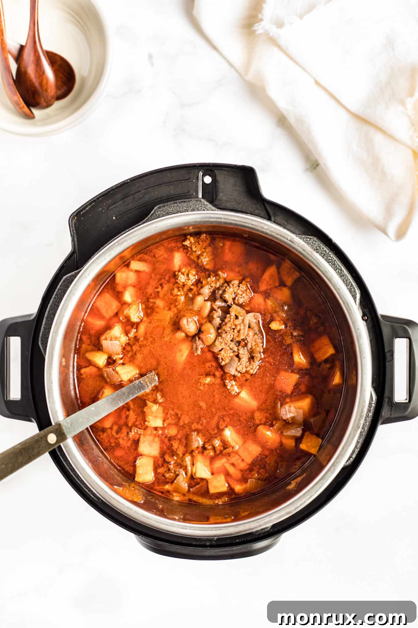 cooked sweet potato chili in an instant pot pressure cooker with a serving spoon.