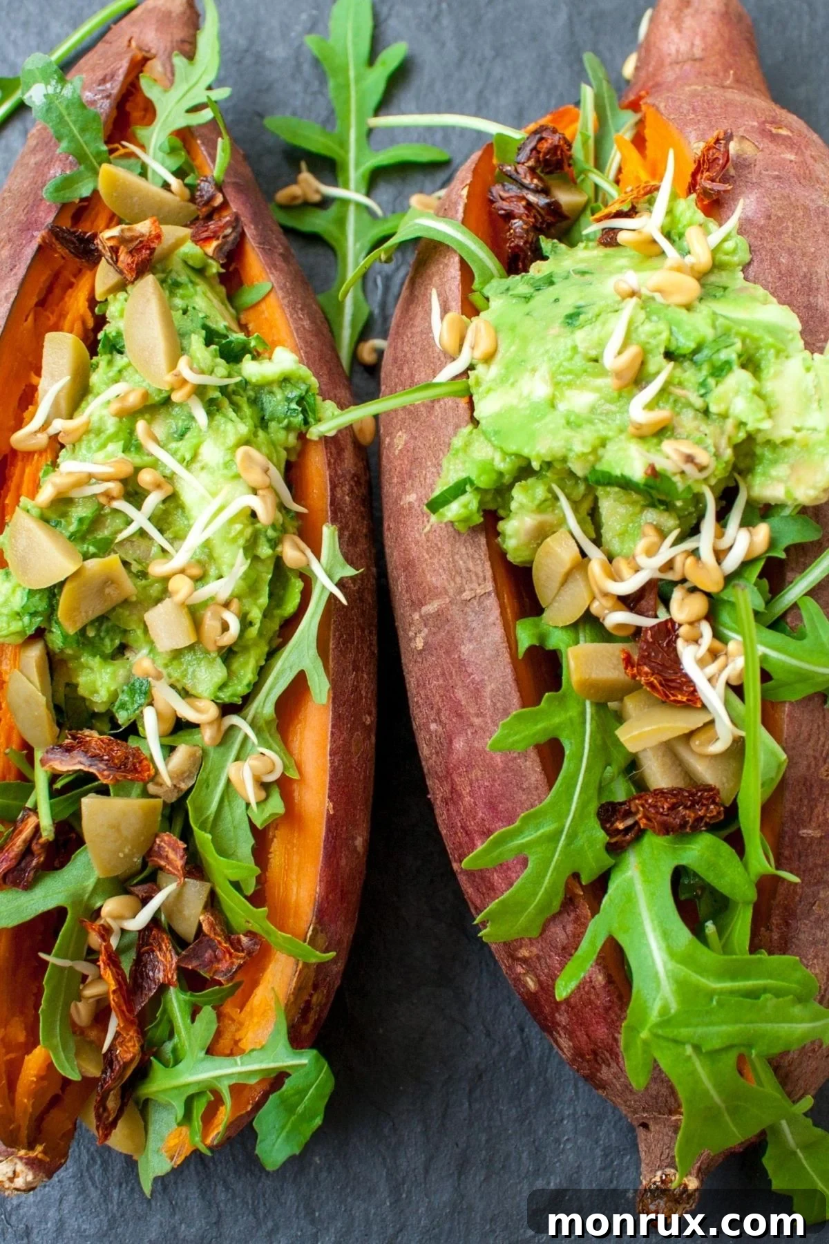 Perfectly cooked sweet potatoes topped with fresh guacamole, showcasing a delicious complex carbohydrate meal.