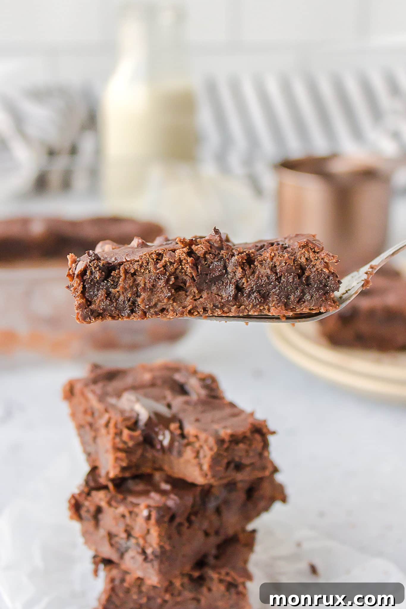 Close-up of a perfectly cut slice of fudgy vegan black bean brownie, showing its dense texture and melted chocolate chips.