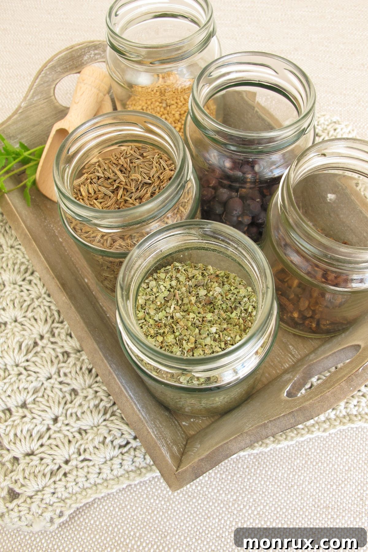 Selection of dried herbs and spices on a table, including turmeric, cumin, and basil for clean eating