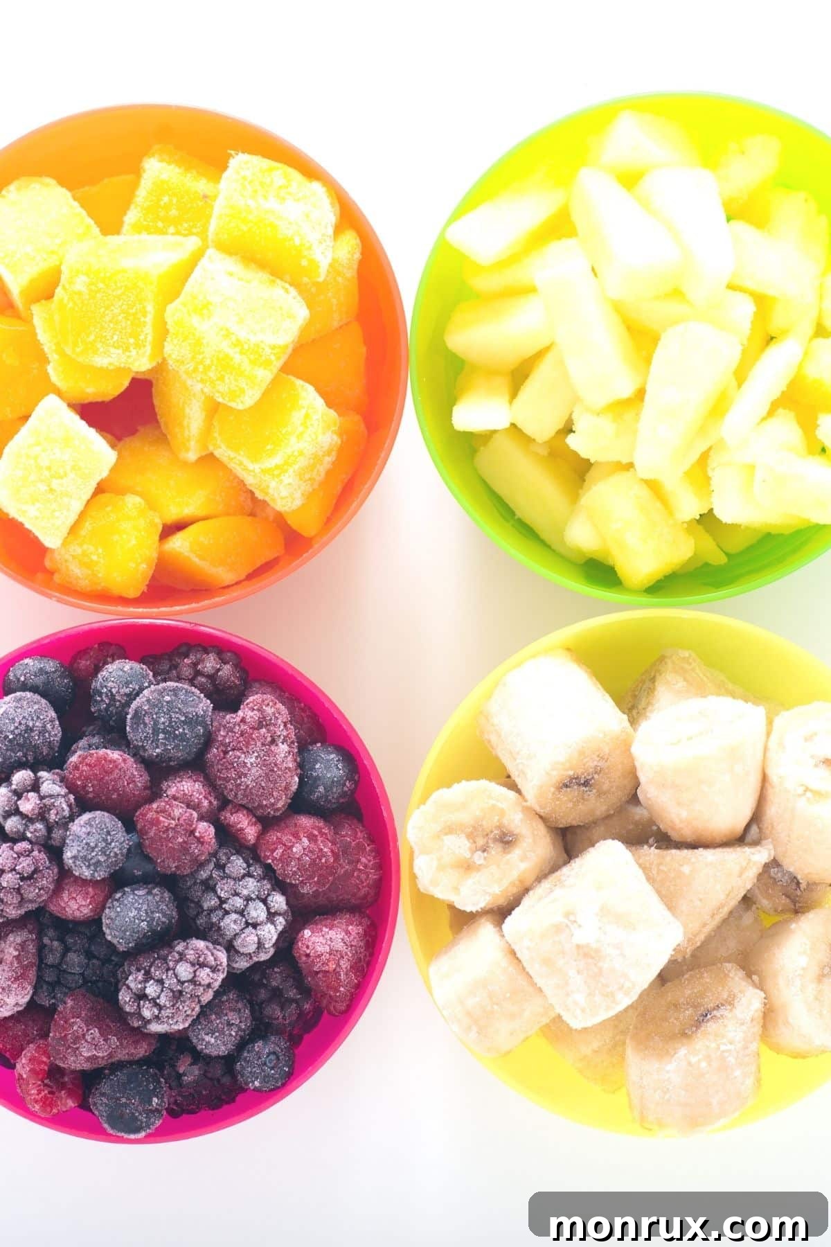 Bowl of frozen bananas, berries, mango, and pineapple, ideal for clean eating smoothies