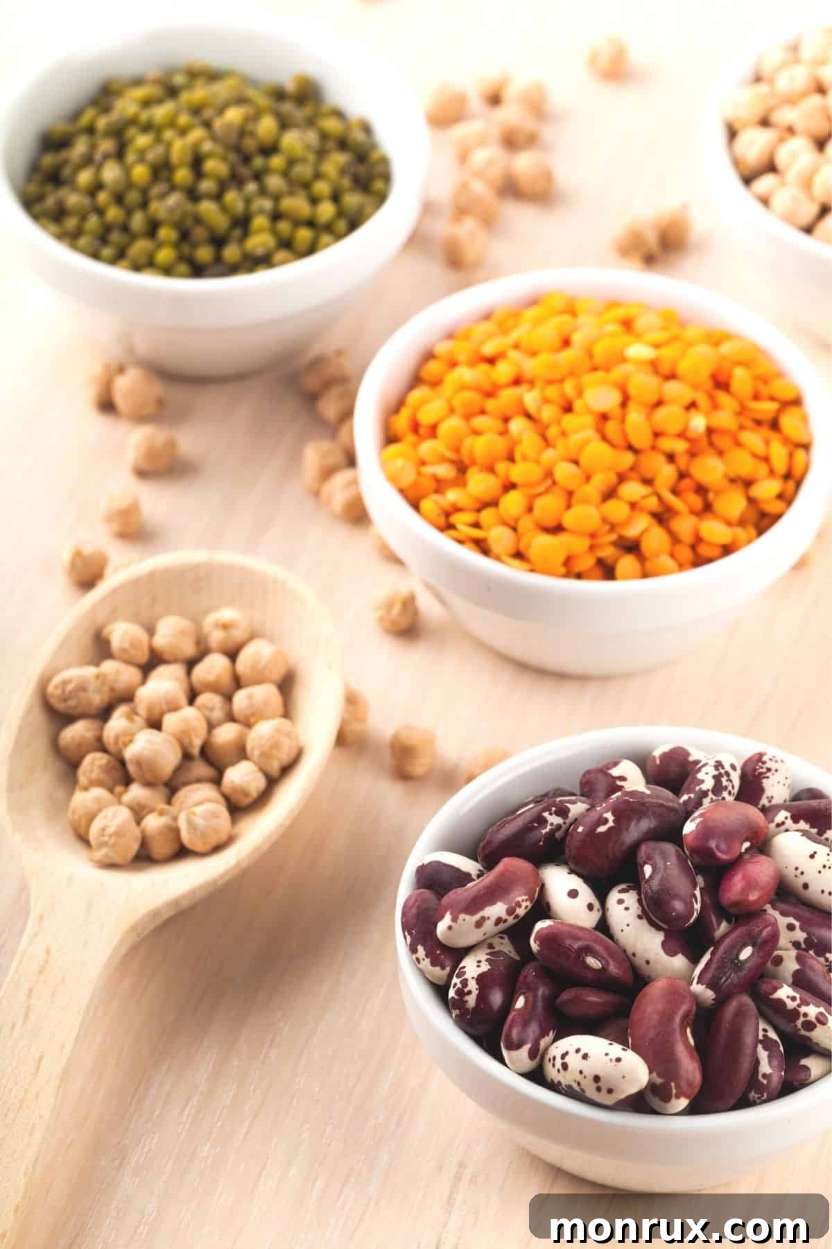 Bowls of various dried beans and peas, representing versatile clean eating legumes