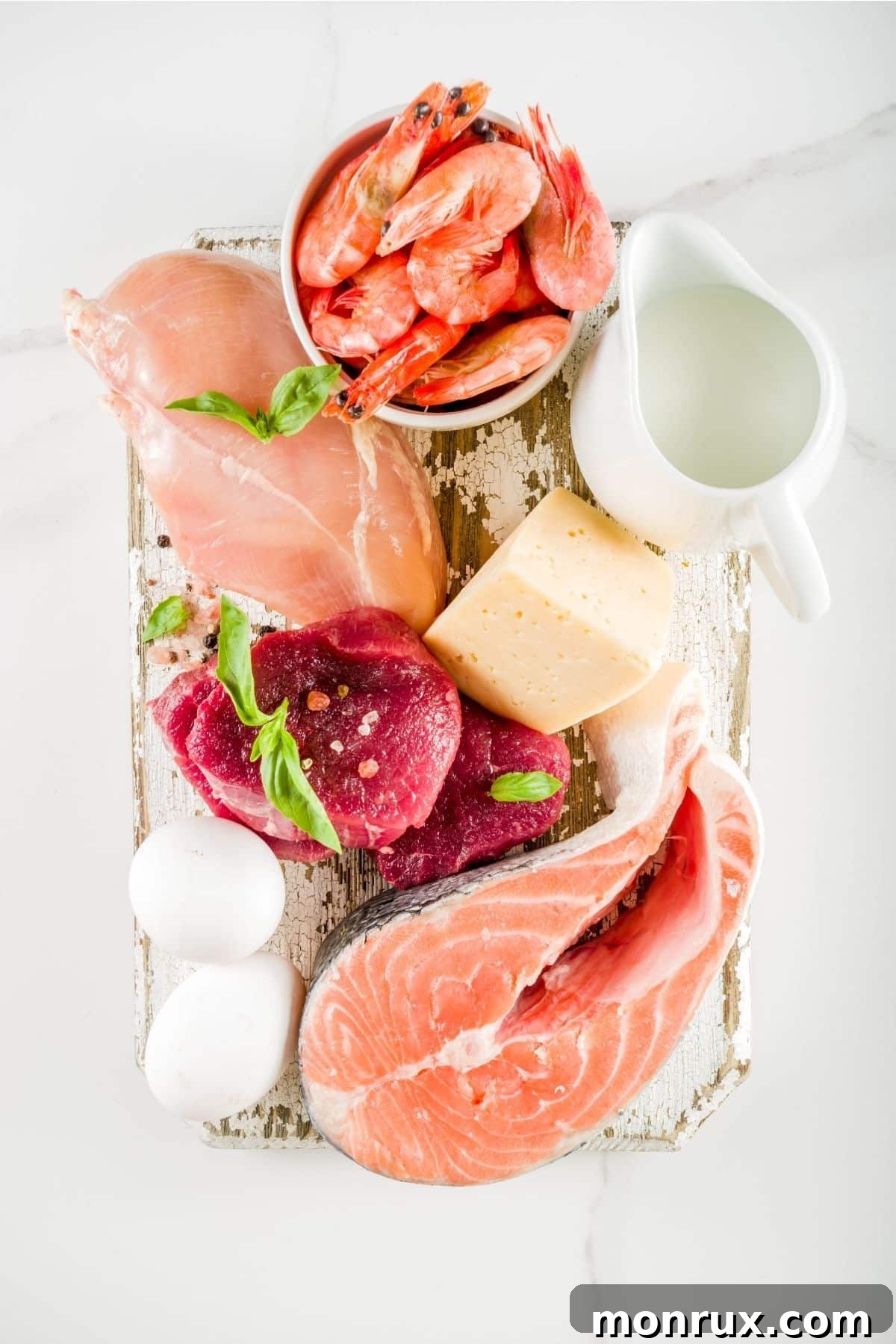 Raw chicken, beef, and fish on a wooden board, representing clean eating protein sources