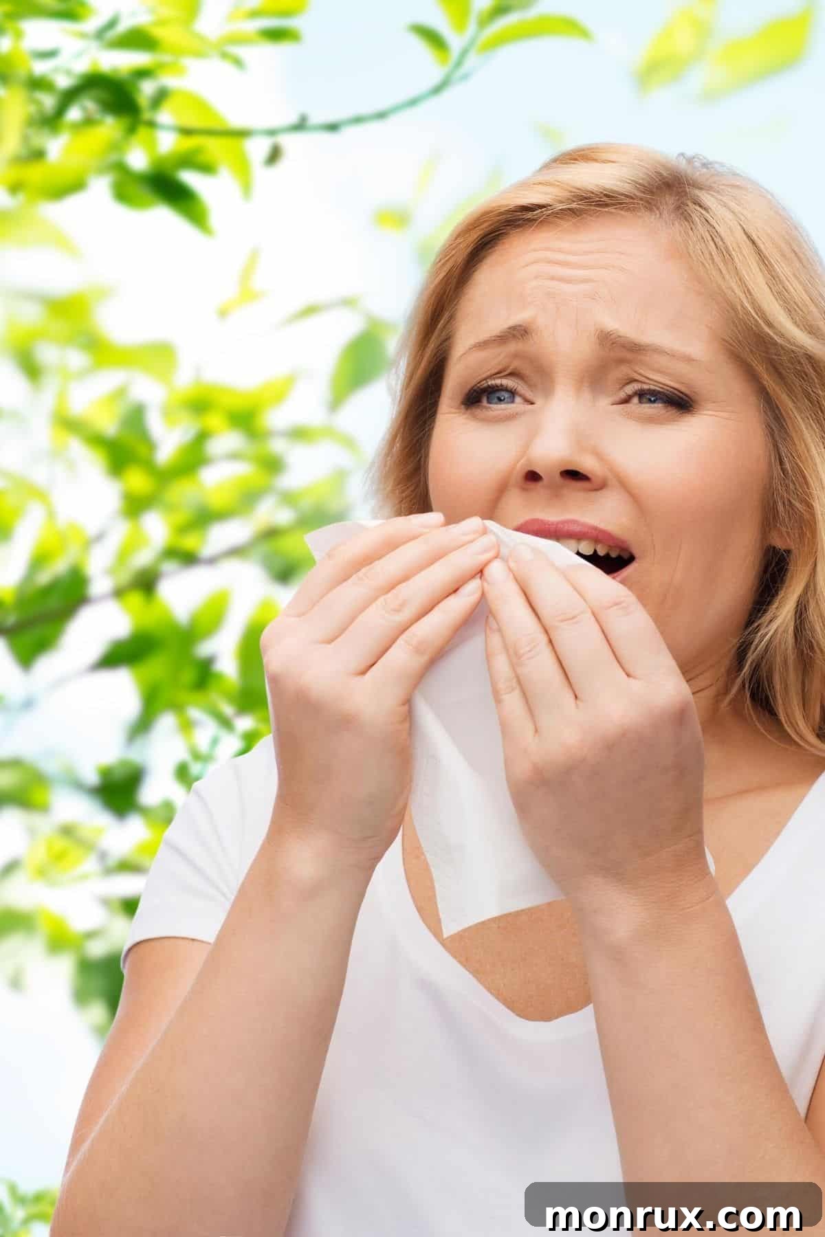 Woman outside sneezing into a tissue, illustrating allergy-like symptoms.