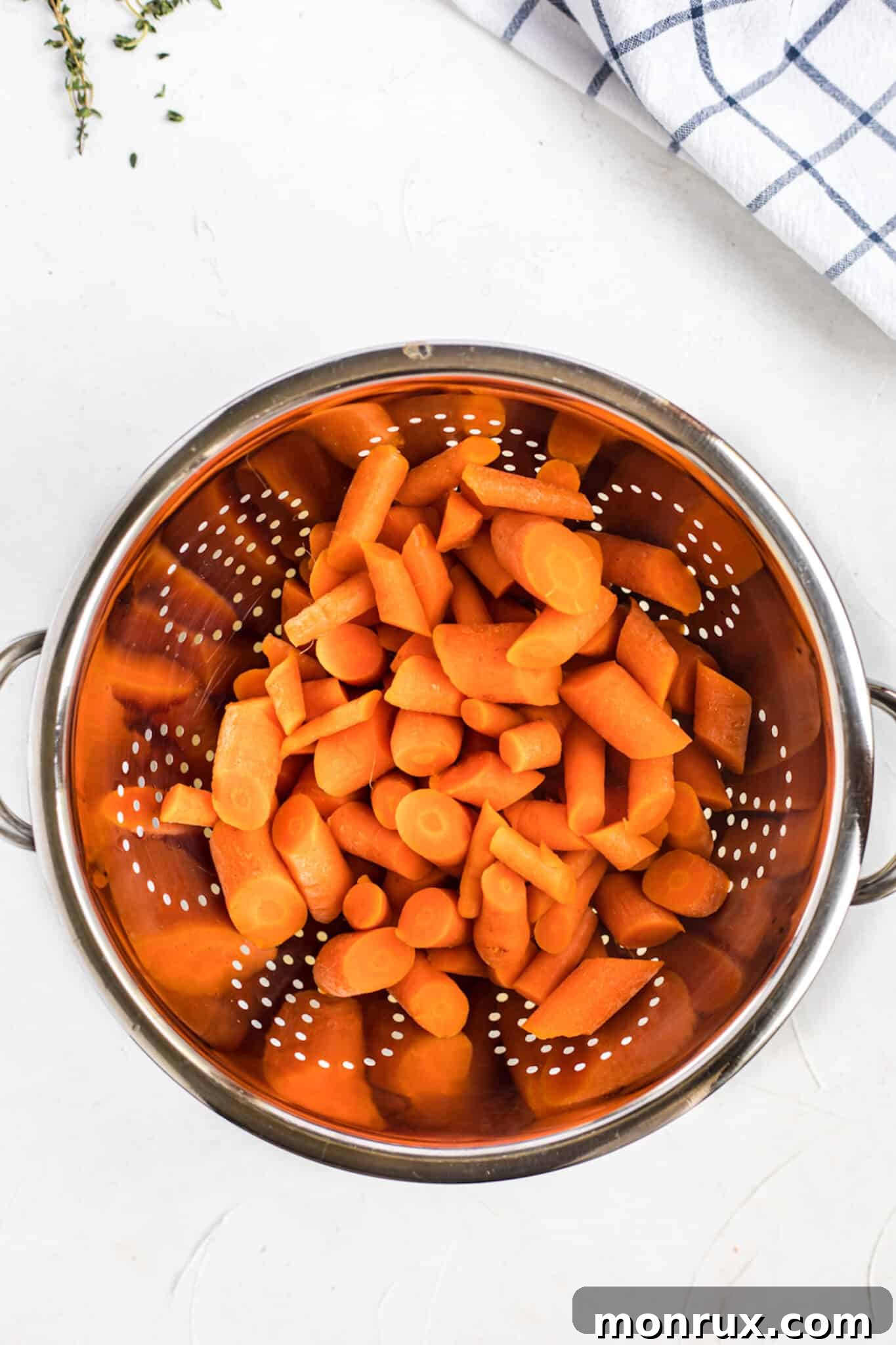 draining cooked carrots.