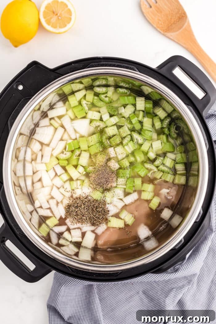 Chopped vegetables and raw chicken combined in an Instant Pot liner for chicken rice soup.