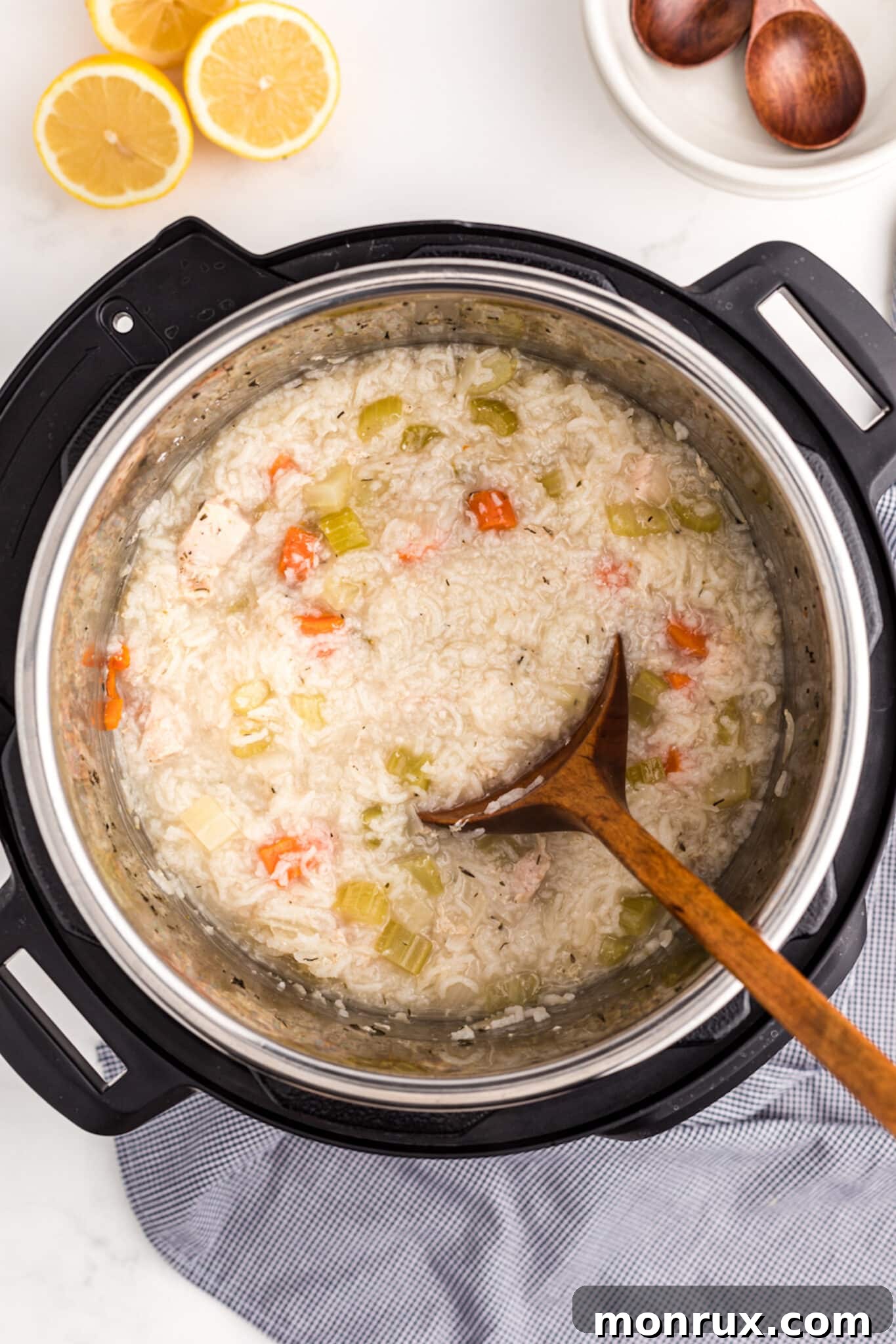 Stirring fresh lemon juice into the cooked chicken and rice soup.
