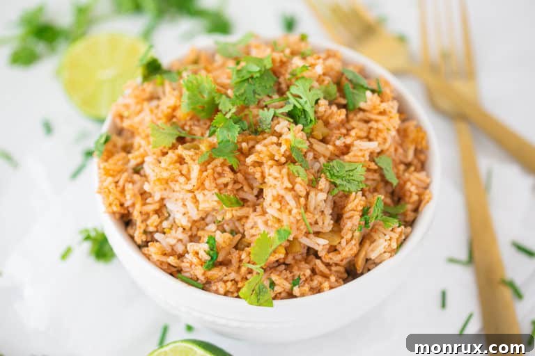 Spanish rice in a bowl with two gold forks.