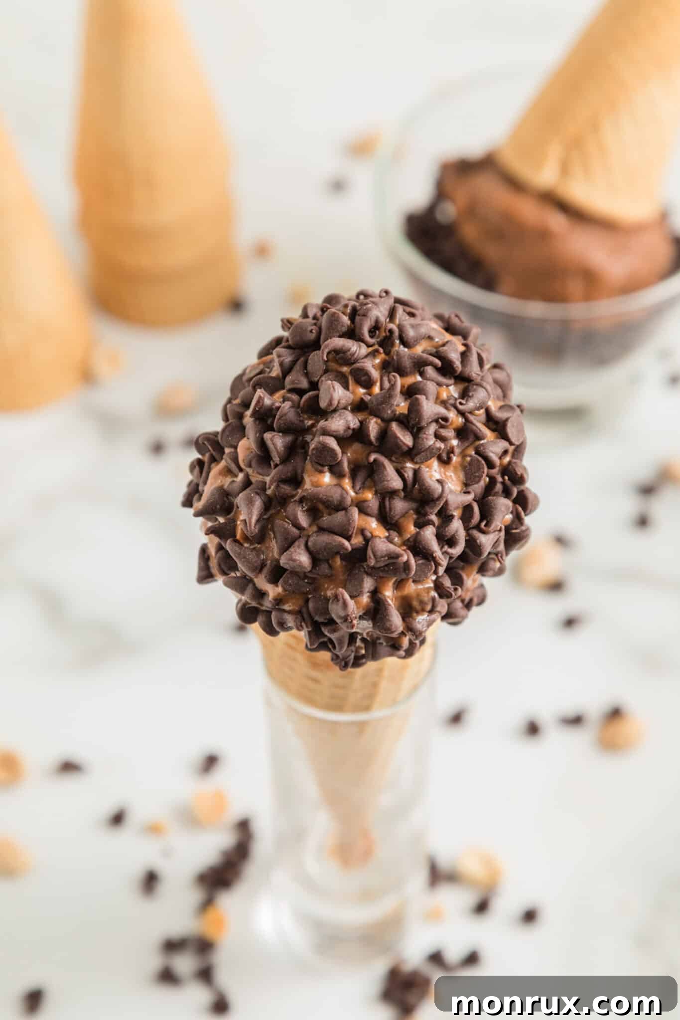 A scoop of Chocolate Peanut Butter Banana Ice Cream elegantly placed in a waffle cone, adorned with chocolate chips for a gourmet touch.