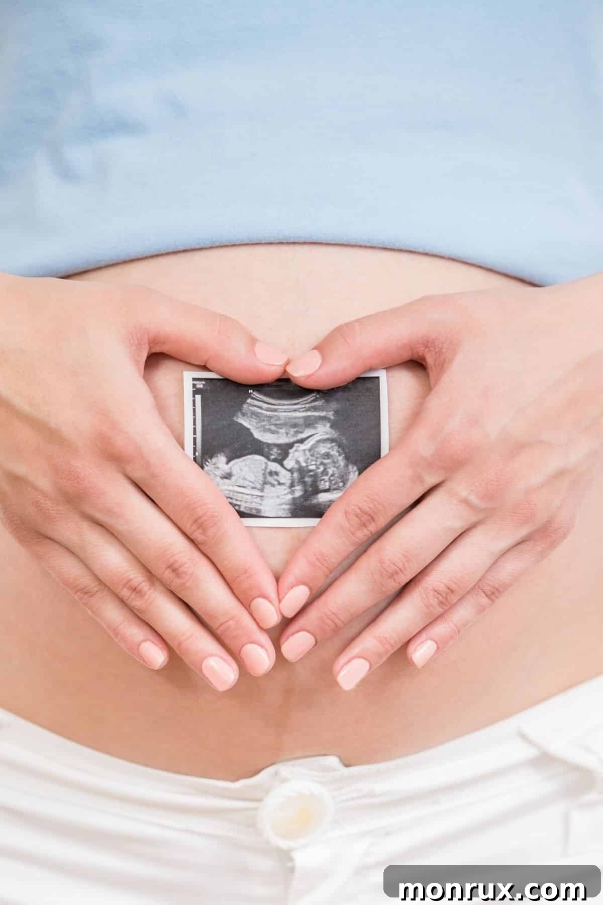Pregnant woman holding ultrasound picture, symbolizing hope and new beginnings related to fertility and healthy diet.