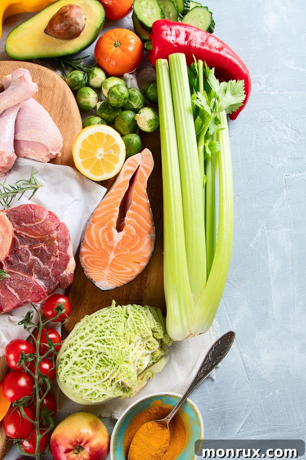 A vibrant selection of healthy, unprocessed foods laid out on a countertop, ready for meal preparation, representing common Paleo ingredients.