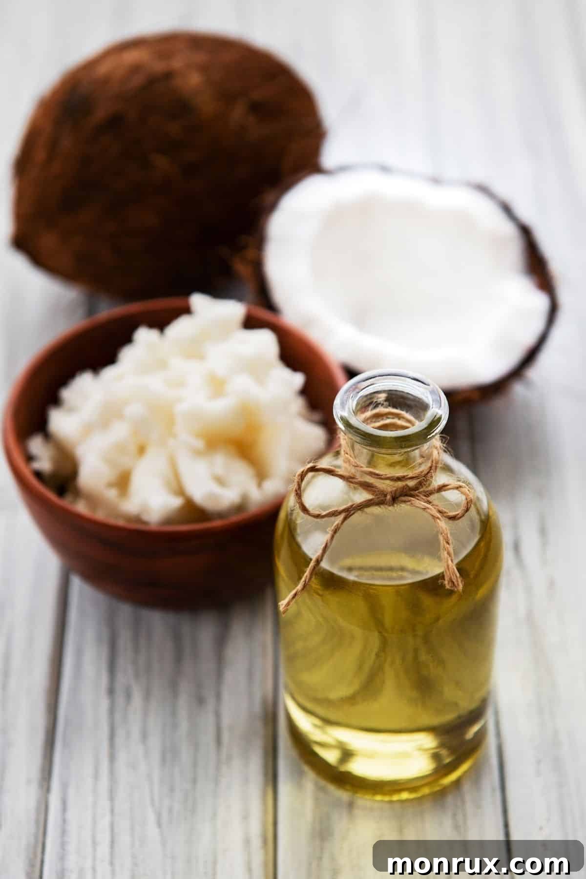 jar of melted coconut oil on a table with some fresh coconut meat