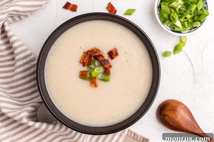 Creamy Instant Pot Cauliflower Soup with a coconut base, garnished with fresh herbs.