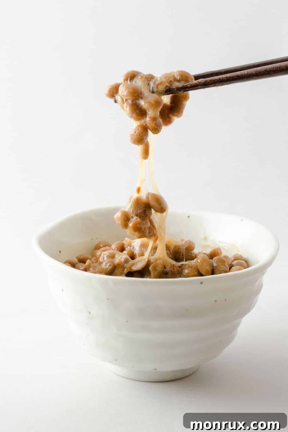A bowl of natto with chopsticks, showcasing its distinctive sticky texture.