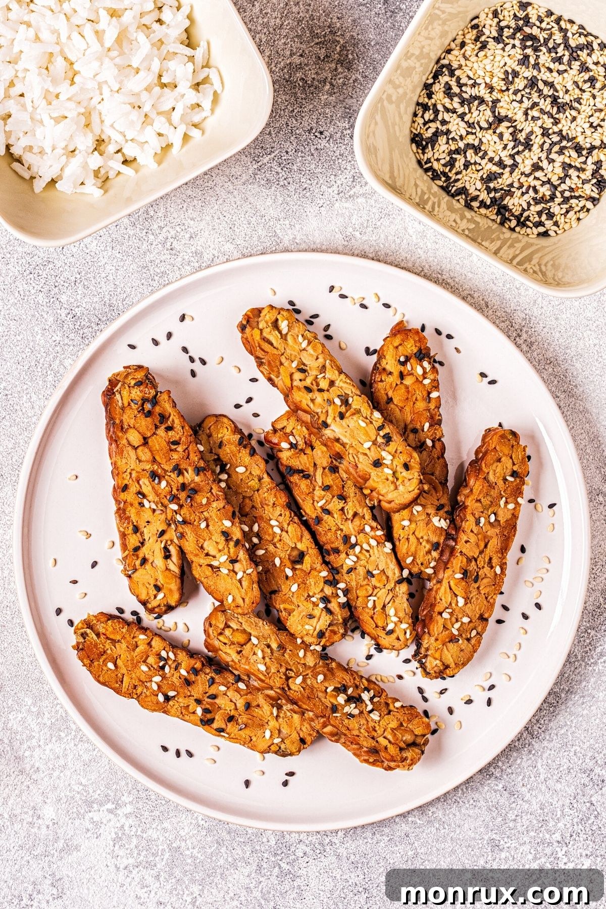 Seasoned and cooked tempeh slices on a plate, highlighting its firm texture and versatility as a plant-based protein.