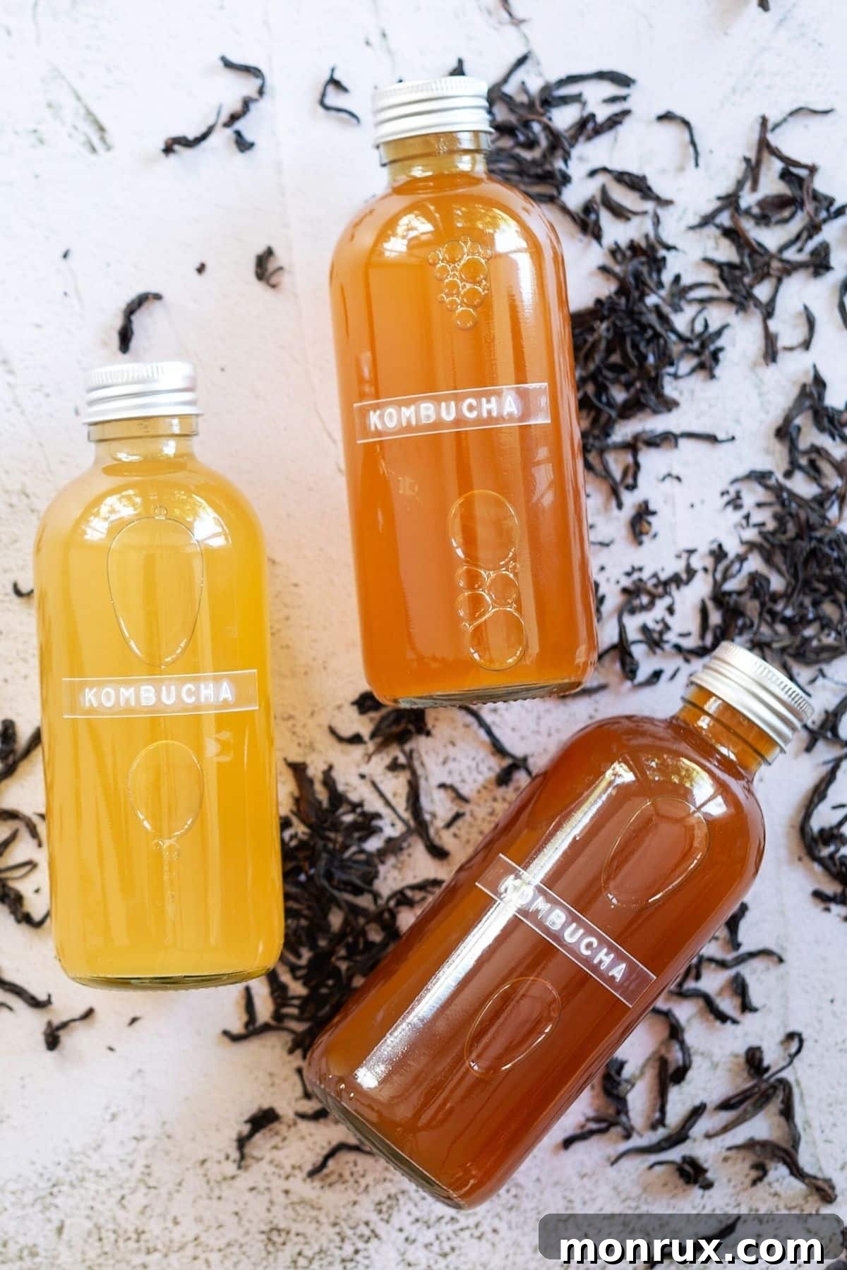 Several glass jars of vibrant kombucha, with distinct layers, showcasing the brewing process and variety of flavors.