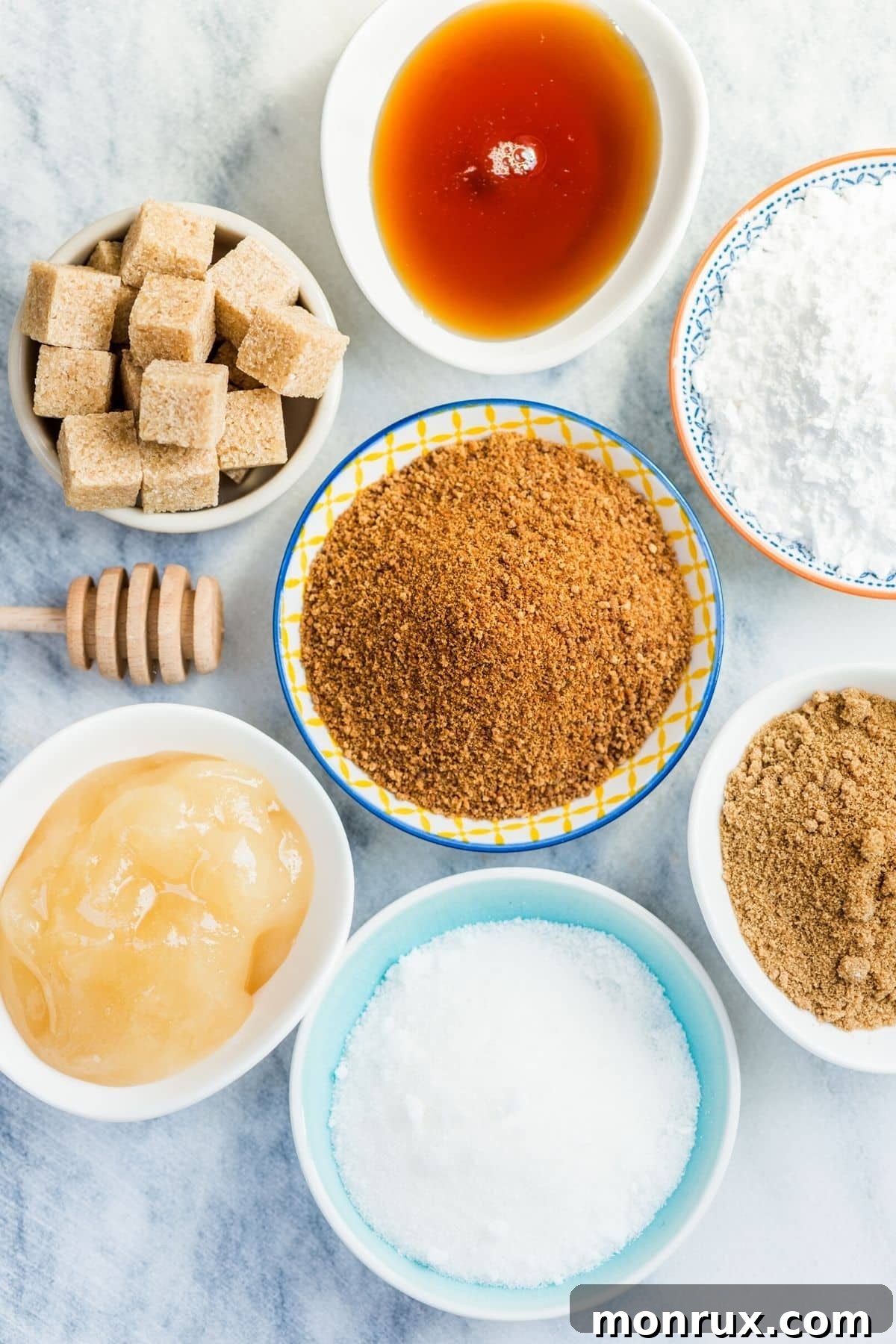 Assortment of natural sugar alternatives in bowls, including monk fruit, stevia, honey, and dates, arranged on a rustic wooden table.