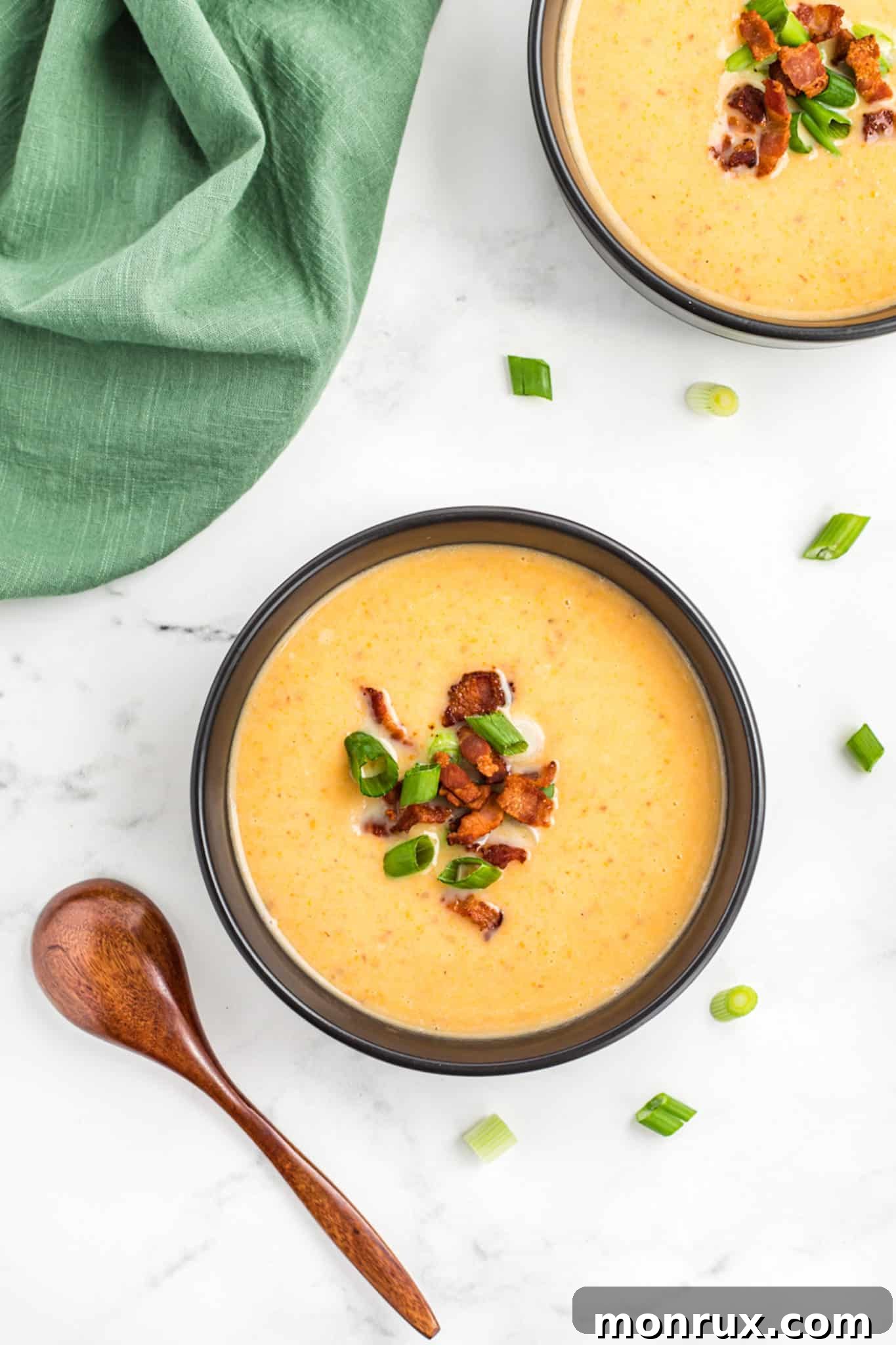 Two bowls of potato soup with bacon and scallions, ready to be enjoyed.