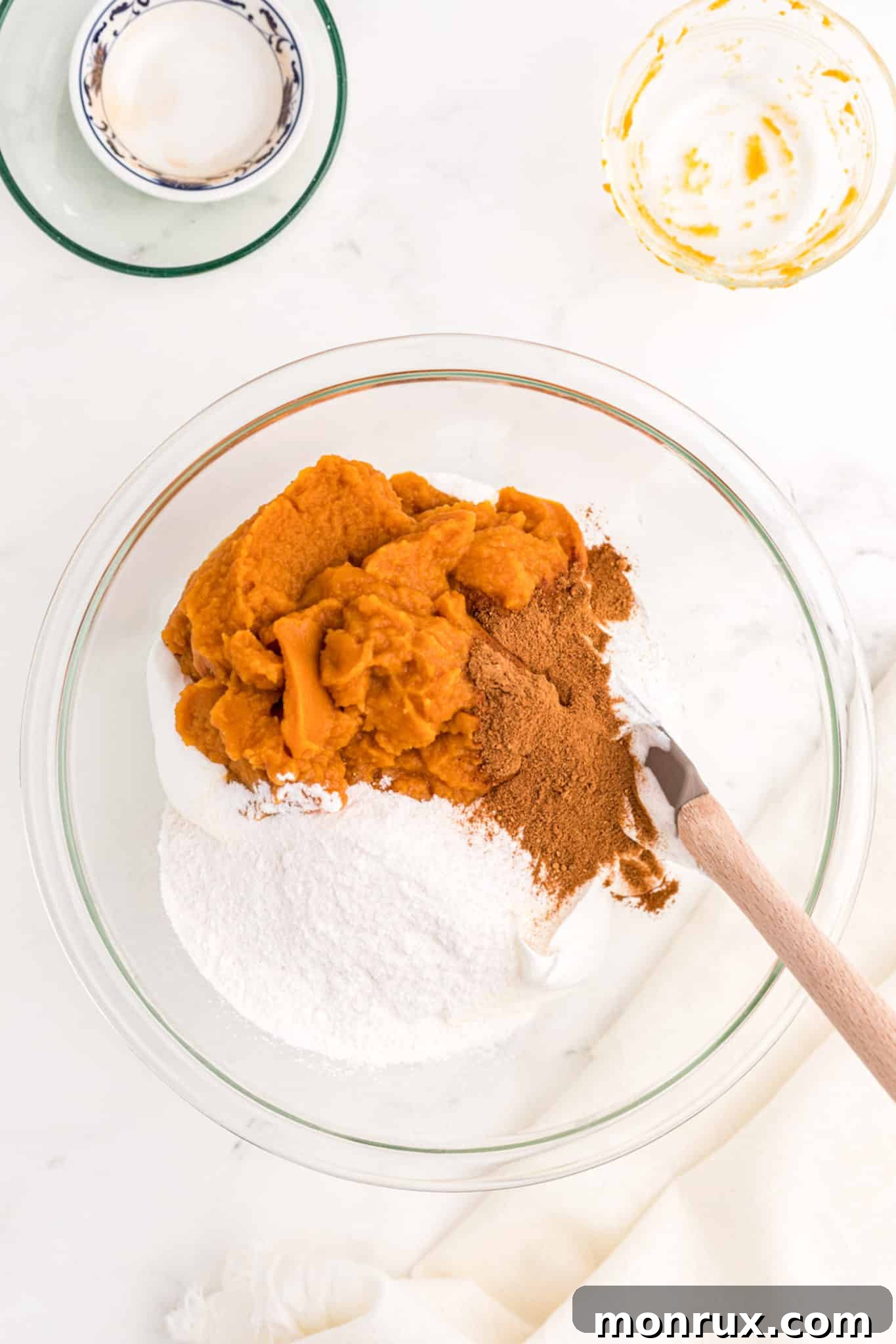 a bowl of whipped topping, spices, and pumpkin puree.