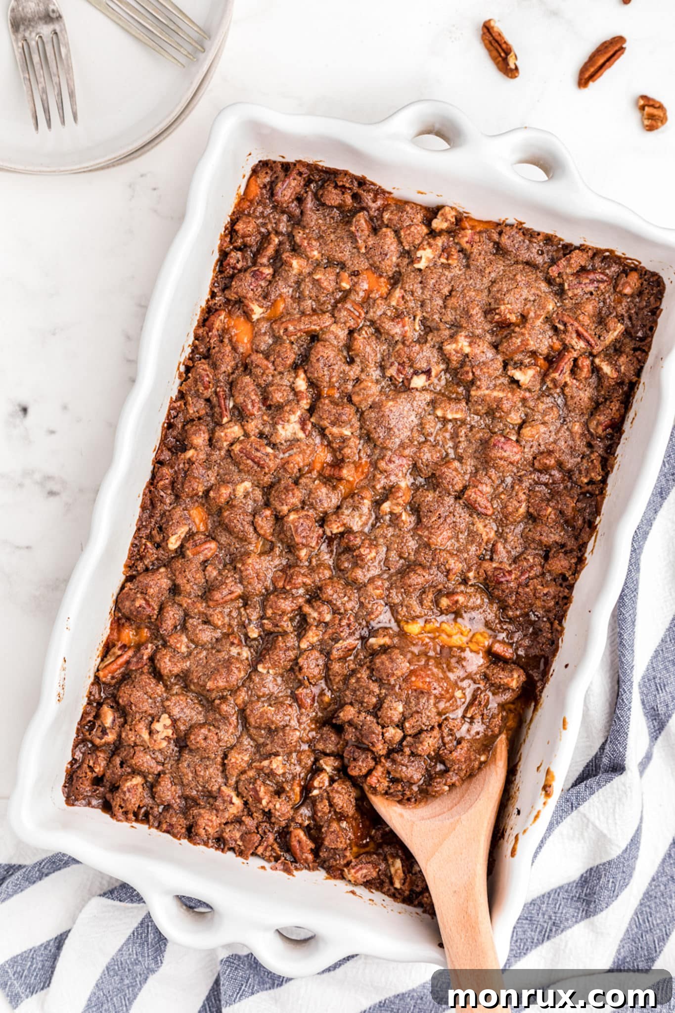 A beautifully presented gluten-free sweet potato casserole, garnished with a golden-brown pecan topping, served in a white baking dish, ready for holiday dining.