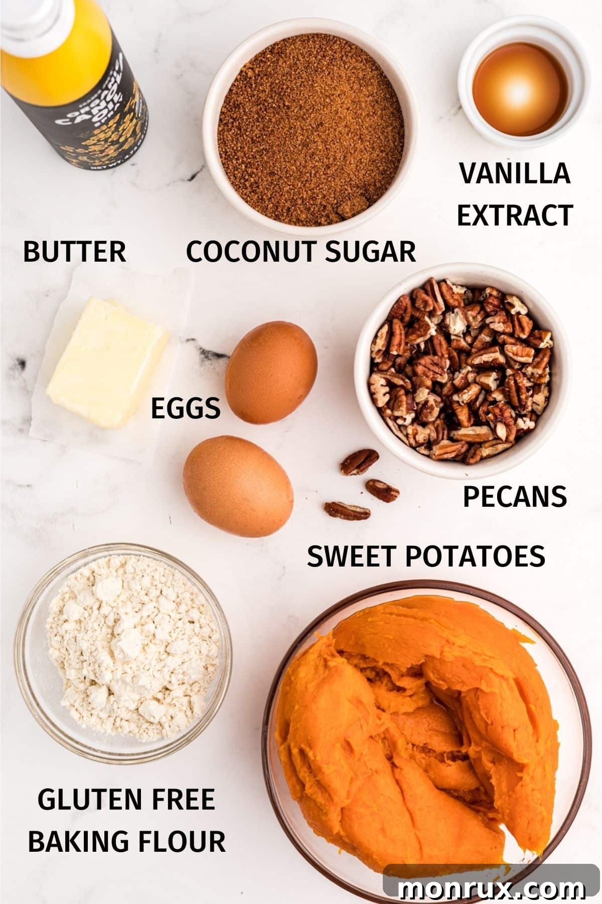 An array of fresh ingredients for gluten-free sweet potato casserole, including whole sweet potatoes, pecans, butter, eggs, and gluten-free flour, laid out on a rustic surface.