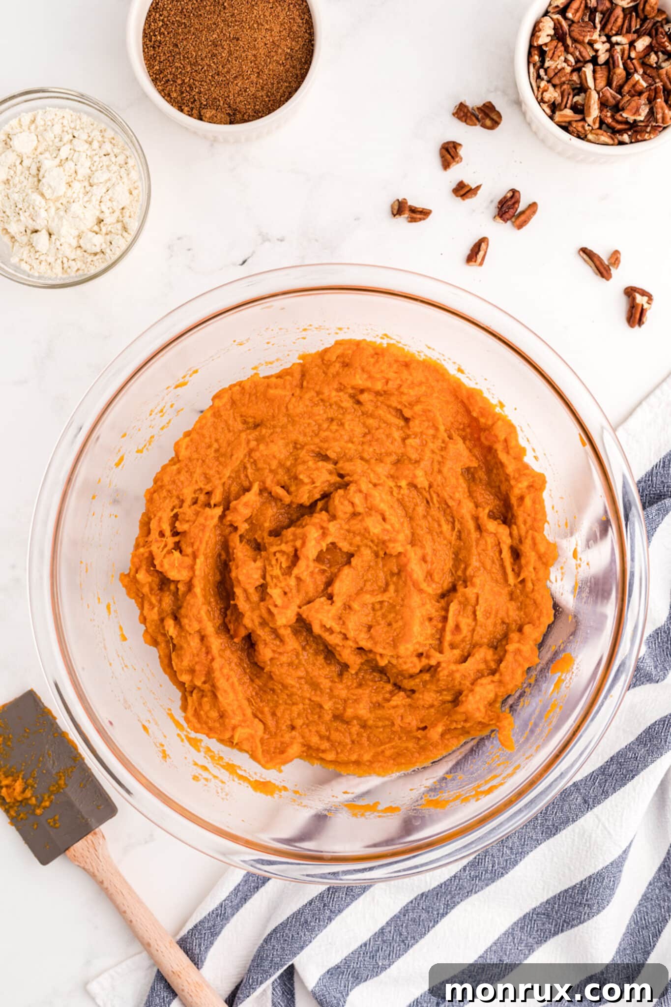 A close-up shot of creamy mashed sweet potatoes in a bowl, blended with other ingredients, forming the smooth filling for the casserole.