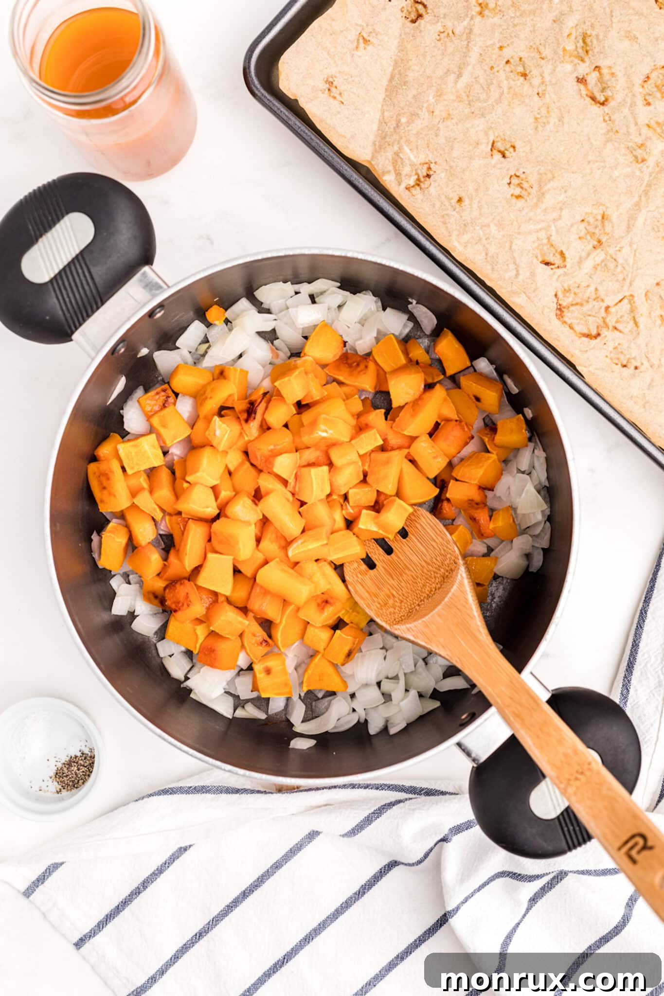Roasted butternut squash and sautéed onions in a large cooking pot.