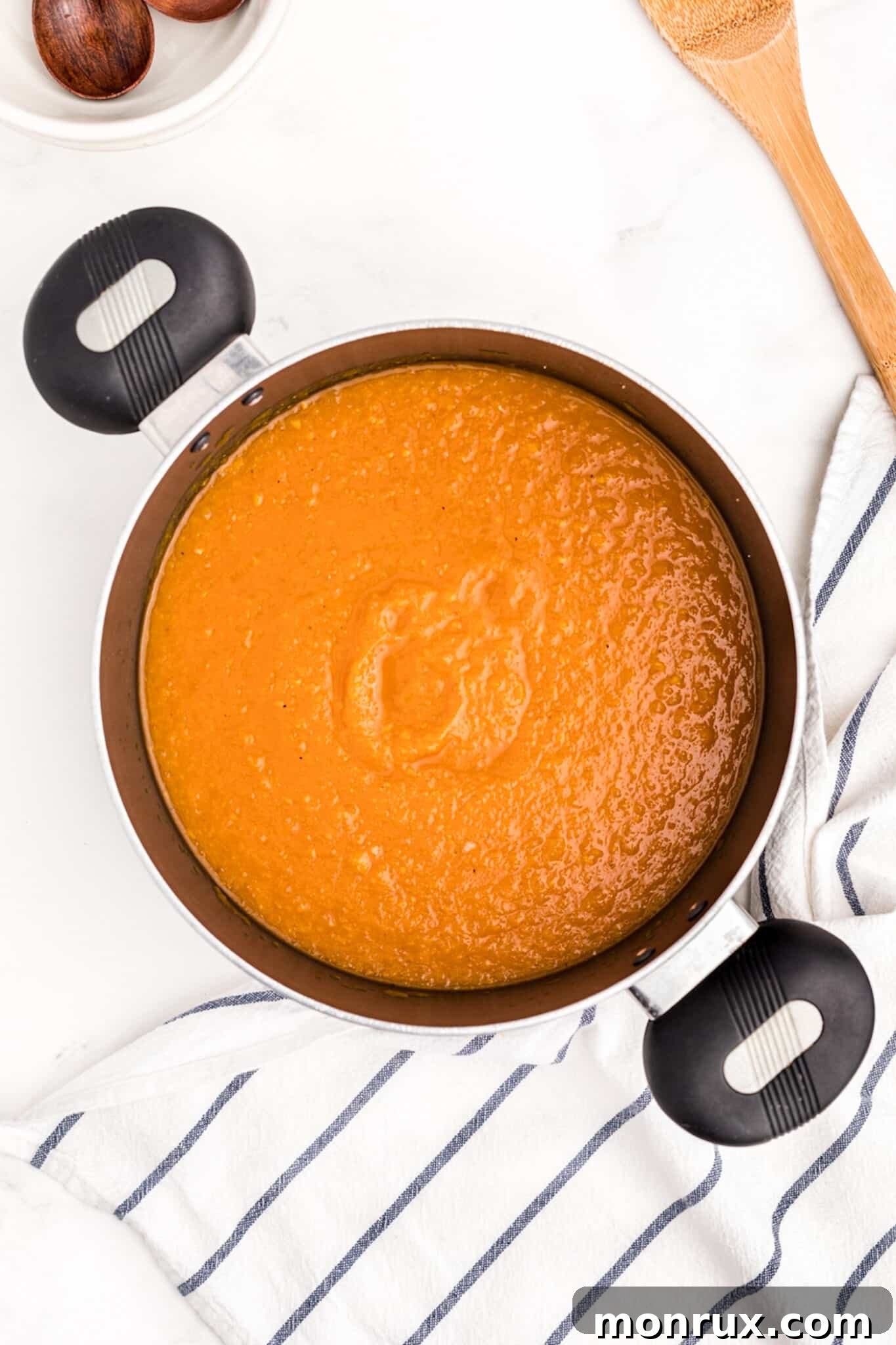 Smooth, pureed butternut squash soup in a cooking pot, ready to serve.