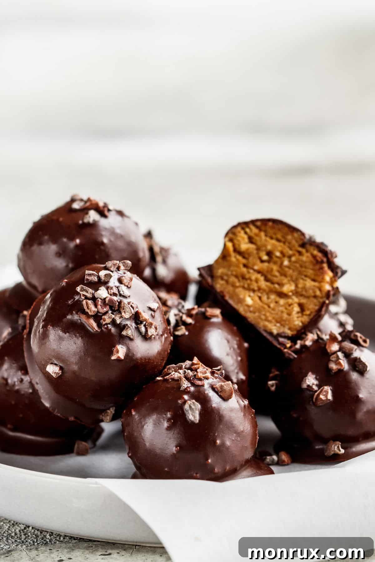 Delicious chocolate tahini truffles in a bowl, garnished with cocoa nibs.