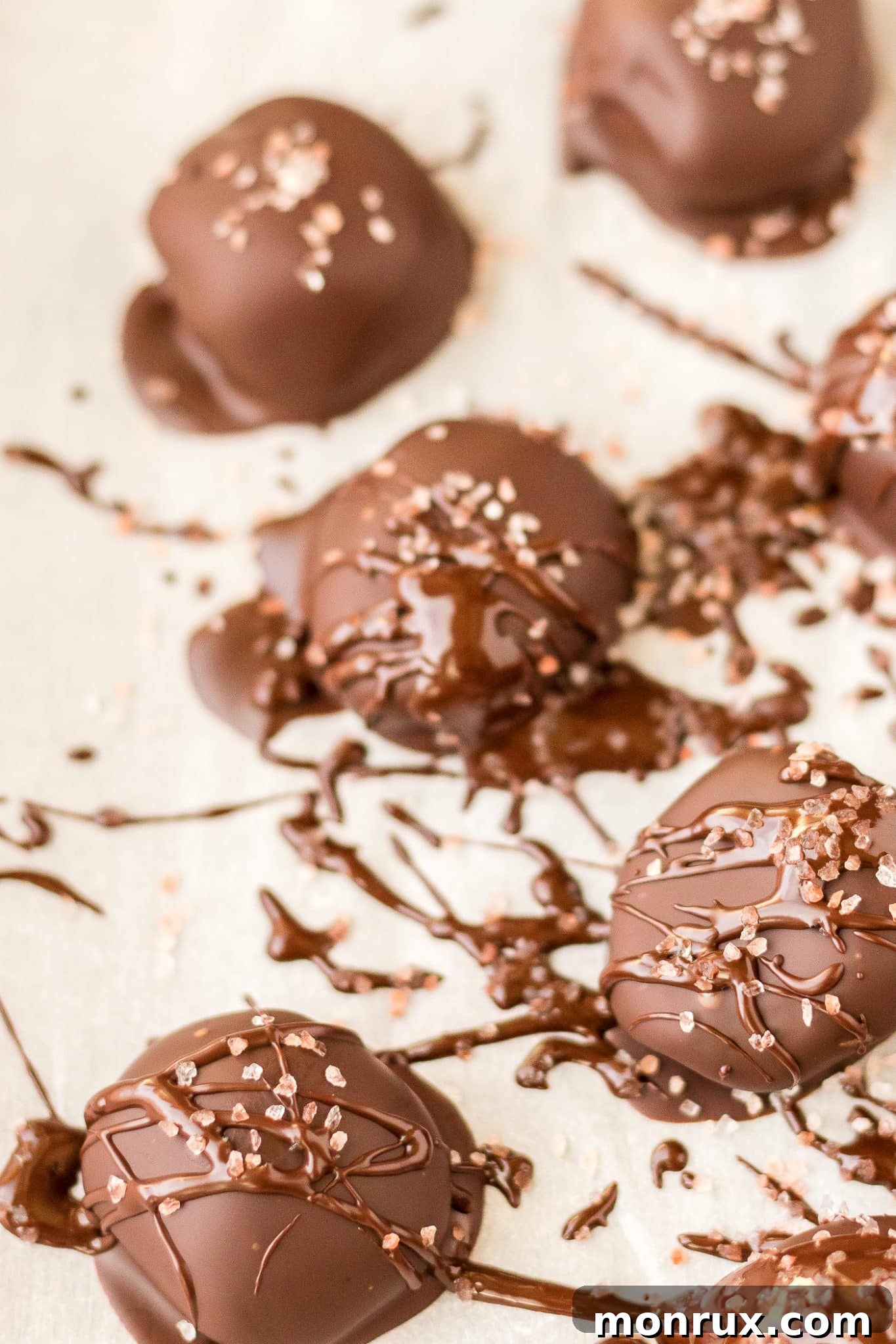 Finished chocolate truffles cooling on parchment paper.