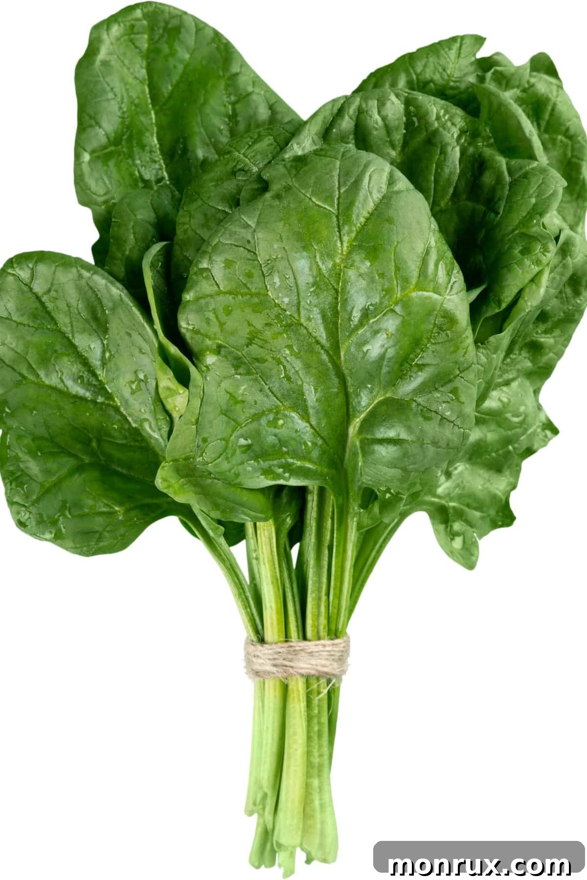 A generous pile of fresh spinach leaves on a light-colored table, signifying freshness and abundance.