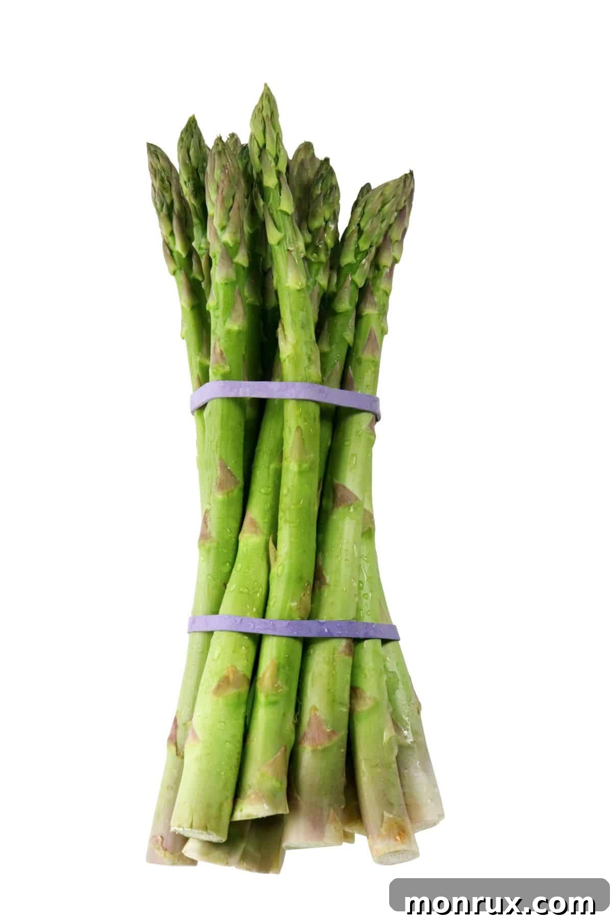 Fresh green asparagus spears neatly bundled and laid on a light wooden table, ready for cooking.