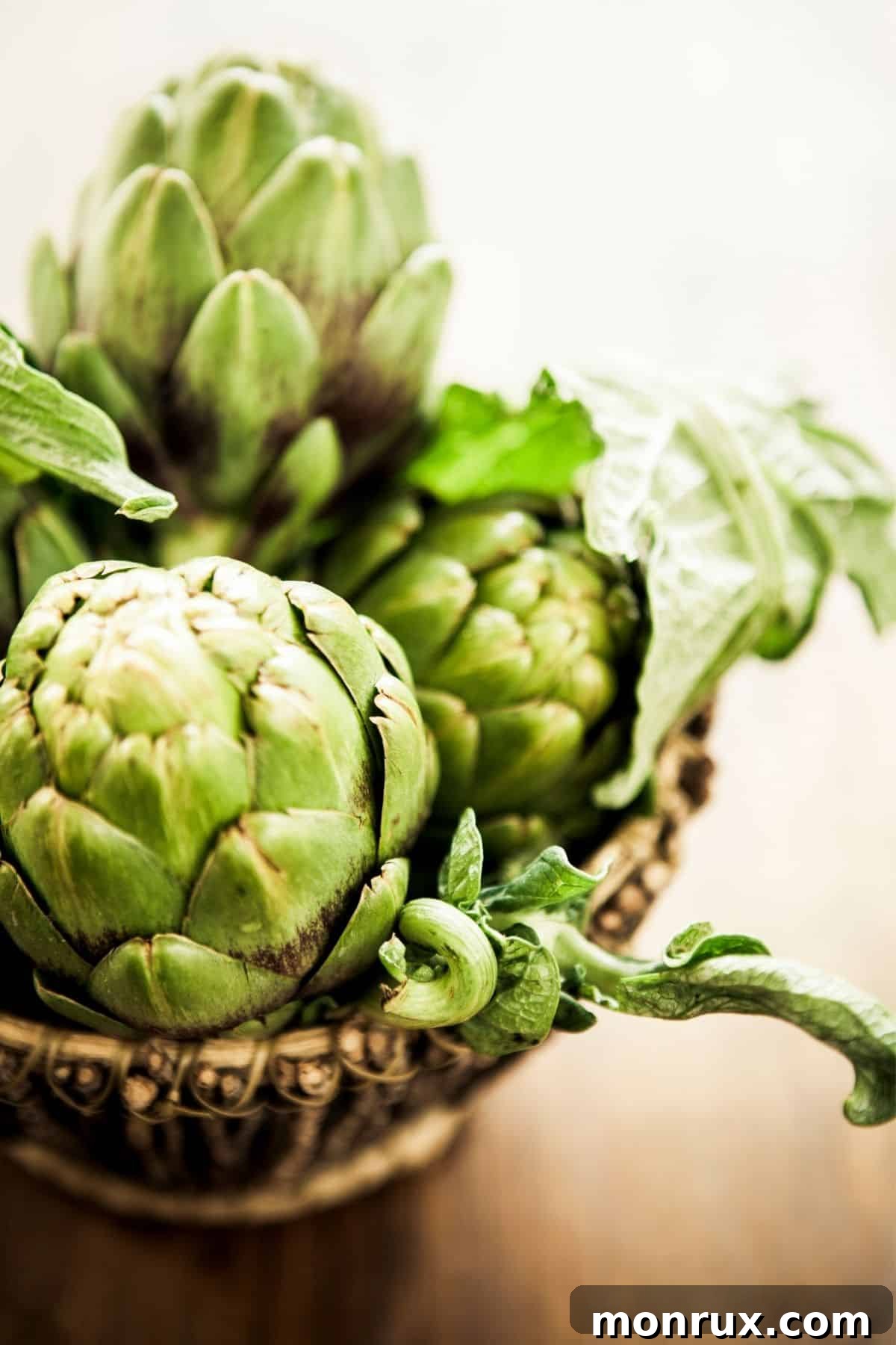 A bowl filled with freshly steamed artichokes, showcasing their layered petals and tender hearts.