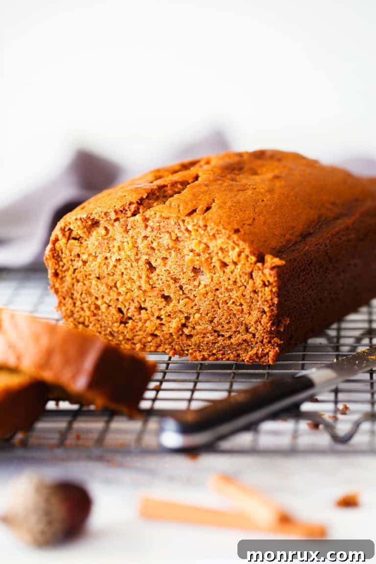 A freshly baked, golden-brown gluten-free sweet potato bread loaf gracefully cooling on a sturdy wire rack.