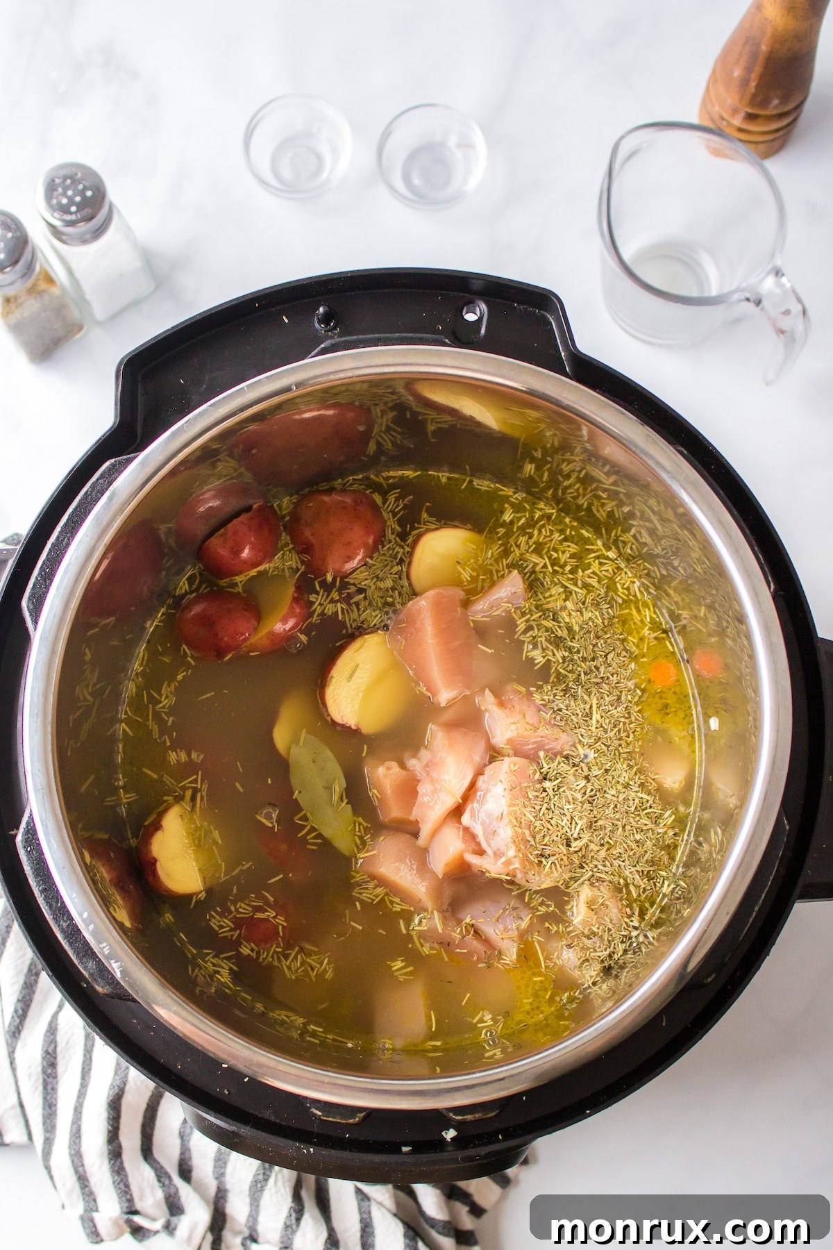 Soup ingredients covered in broth within an Instant Pot, ready for pressure cooking.