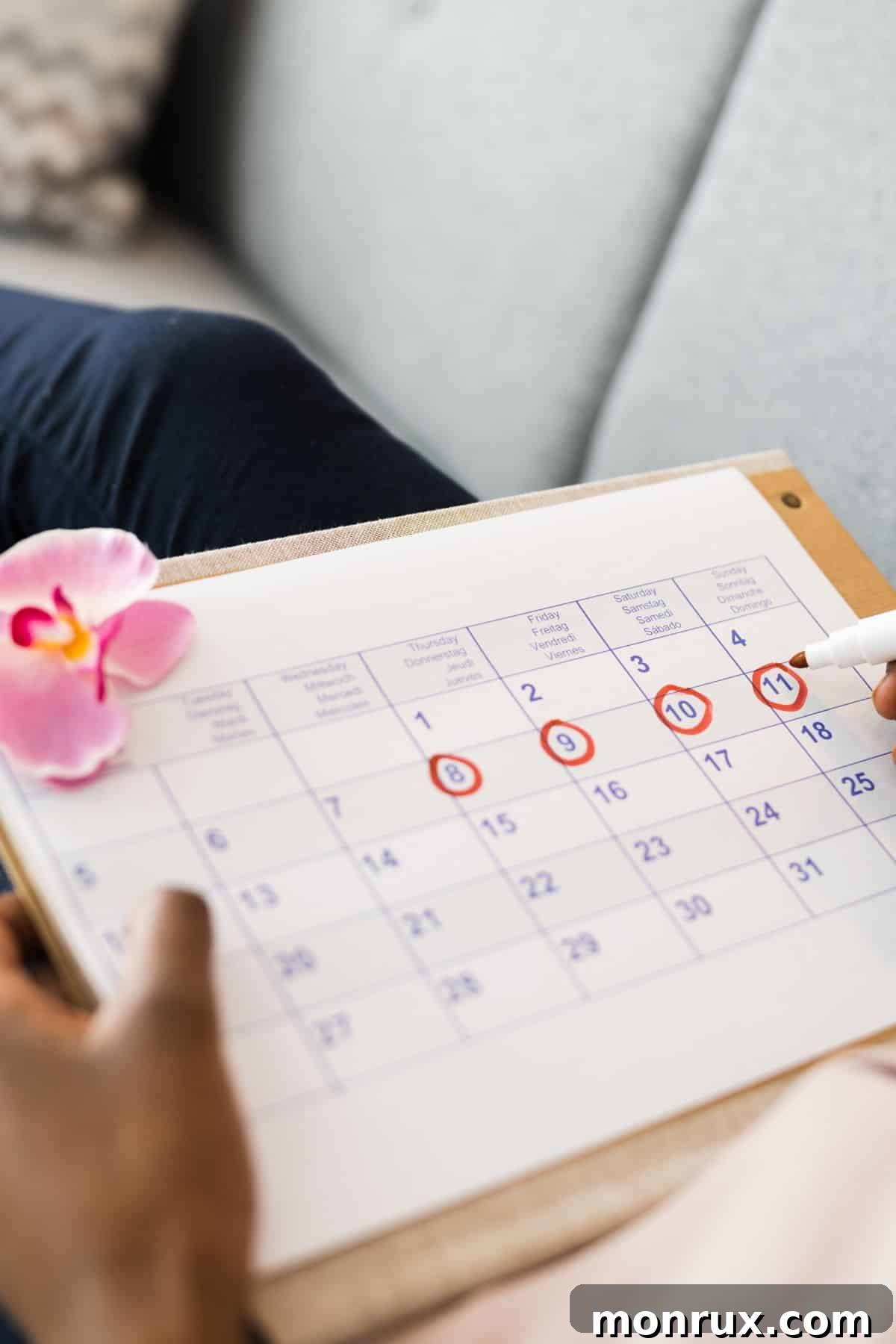 A woman checking off dates on a calendar, symbolizing menstrual cycle tracking and the journey to optimal health through cycle syncing nutrition.