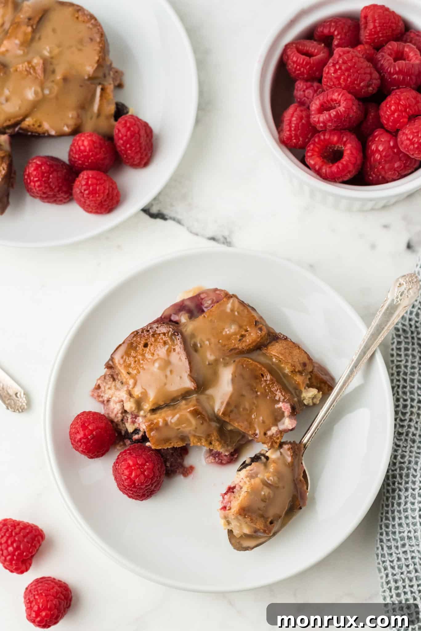 Two plates of delicious gluten-free raspberry bread pudding, perfectly portioned and ready to be enjoyed.